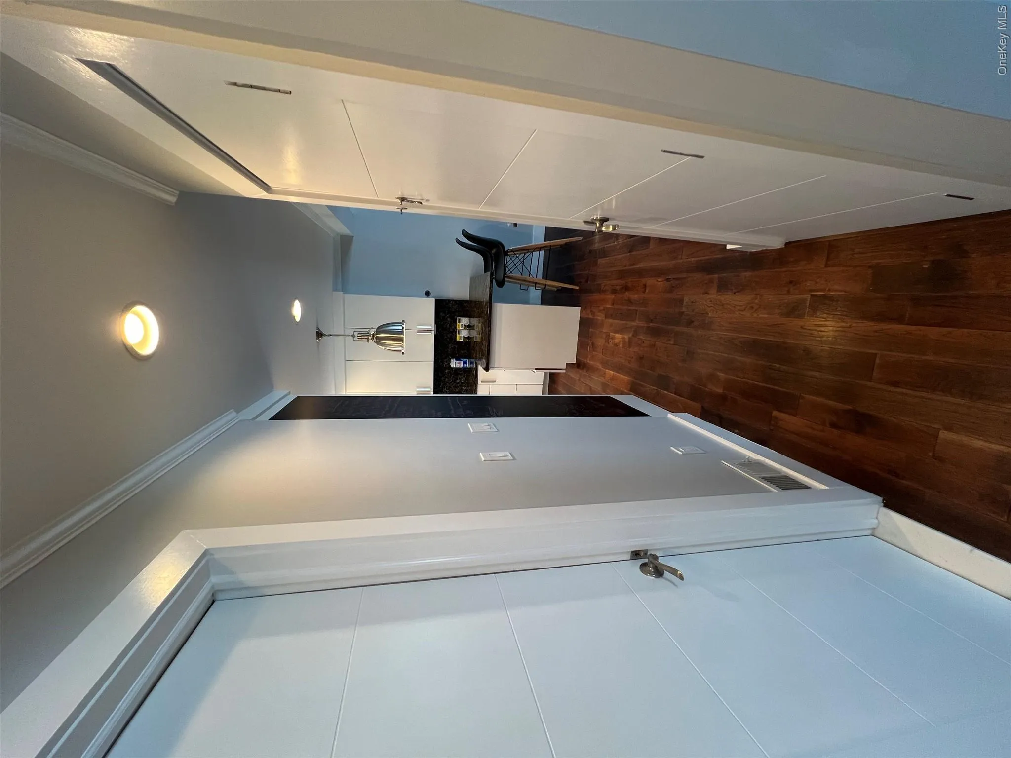 Hallway featuring rich wood-finish flooring, white painted doors, recessed ceiling lighting, and clean white walls with simple trim detailing Hallway featuring rich wood-finish flooring, white painted doors, recessed ceiling lighting, and clean white walls with simple trim detailing