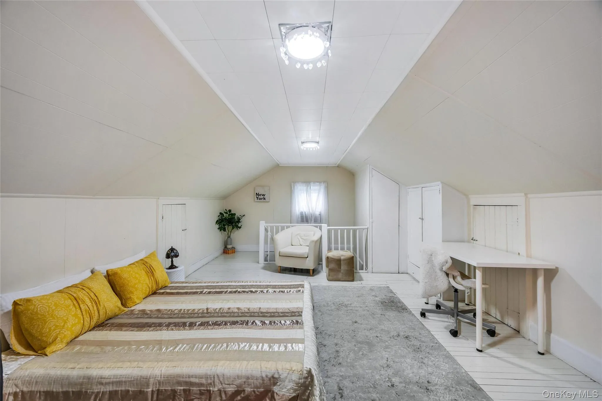 Vaulted ceiling bedroom with white wood-finish flooring, built-in storage cabinets, and recessed wall storage Vaulted ceiling bedroom with white wood-finish flooring, built-in storage cabinets, and recessed wall storage