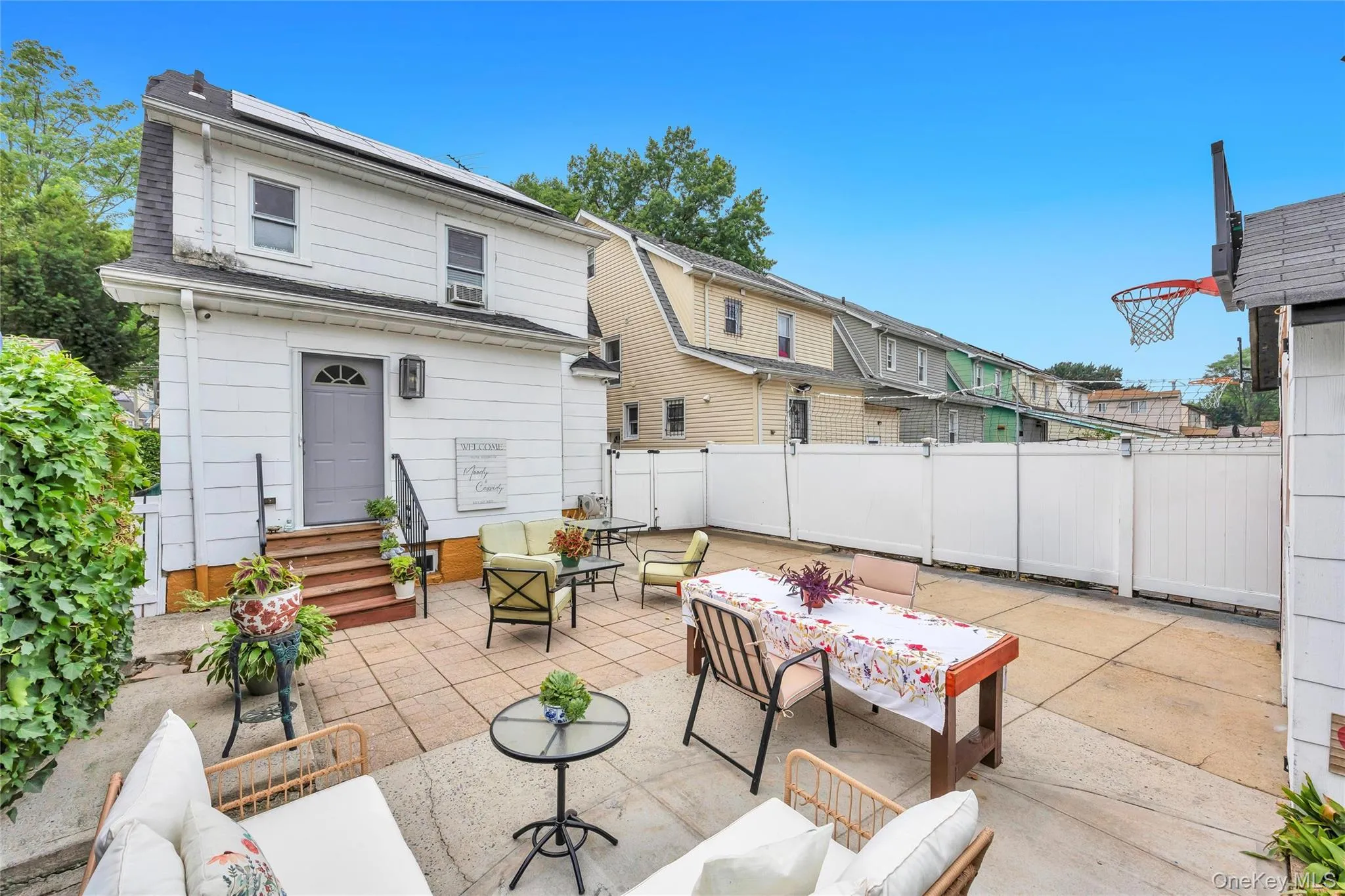 Expansive paved patio area featuring a white privacy fence Expansive paved patio area featuring a white privacy fence