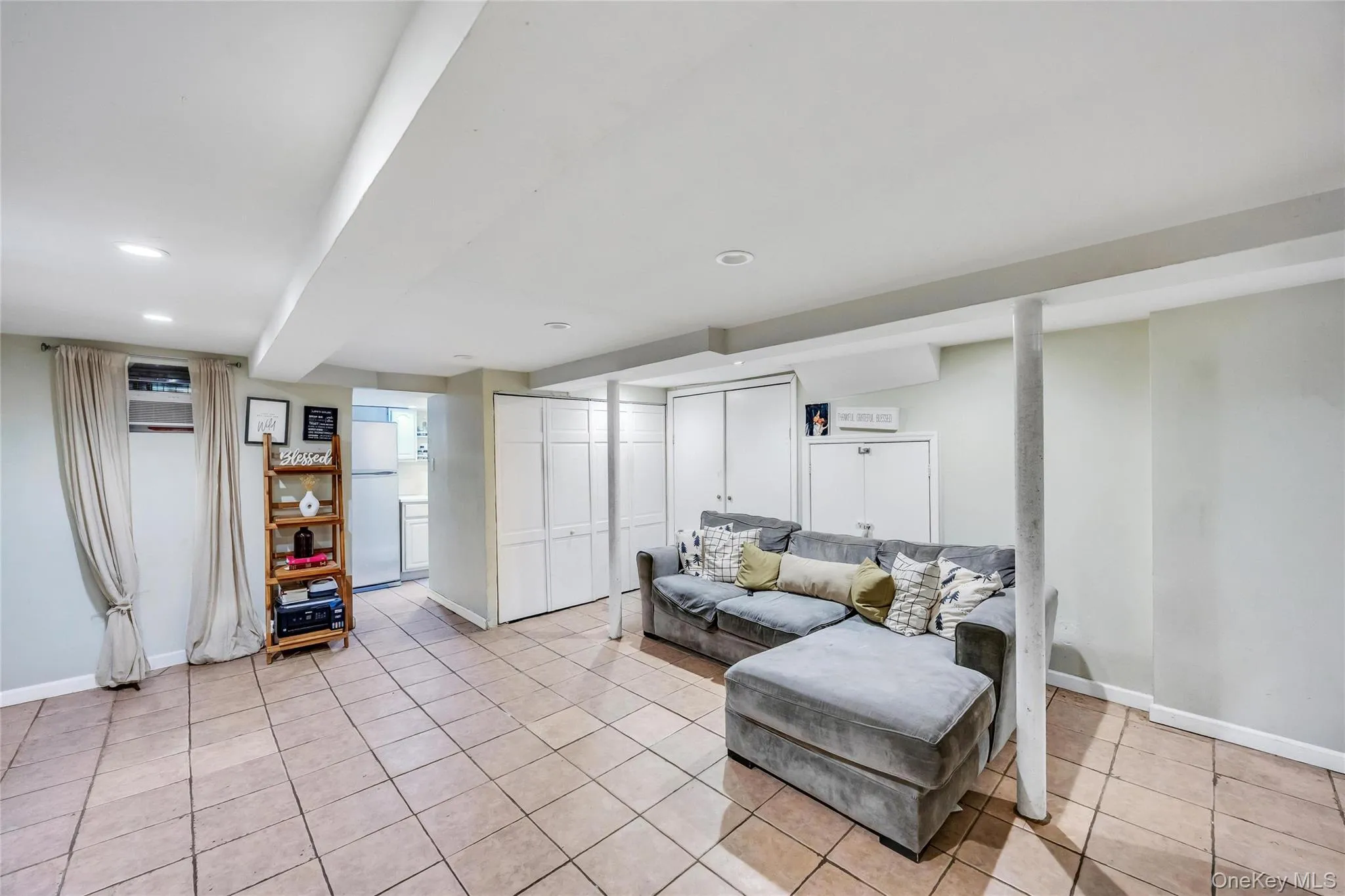 Spacious recreation room featuring tile flooring, recessed lighting, and ample built-in storage with bi-fold doors Spacious recreation room featuring tile flooring, recessed lighting, and ample built-in storage with bi-fold doors