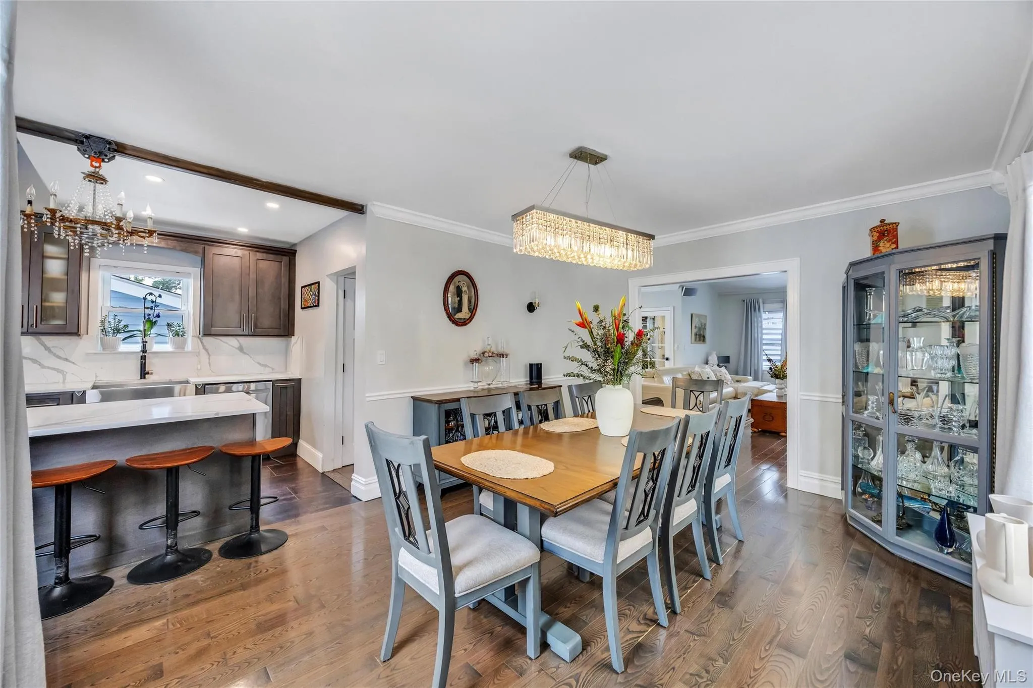 Dining area featuring rich wood-finish flooring and a rectangular crystal chandelier Dining area featuring rich wood-finish flooring and a rectangular crystal chandelier
