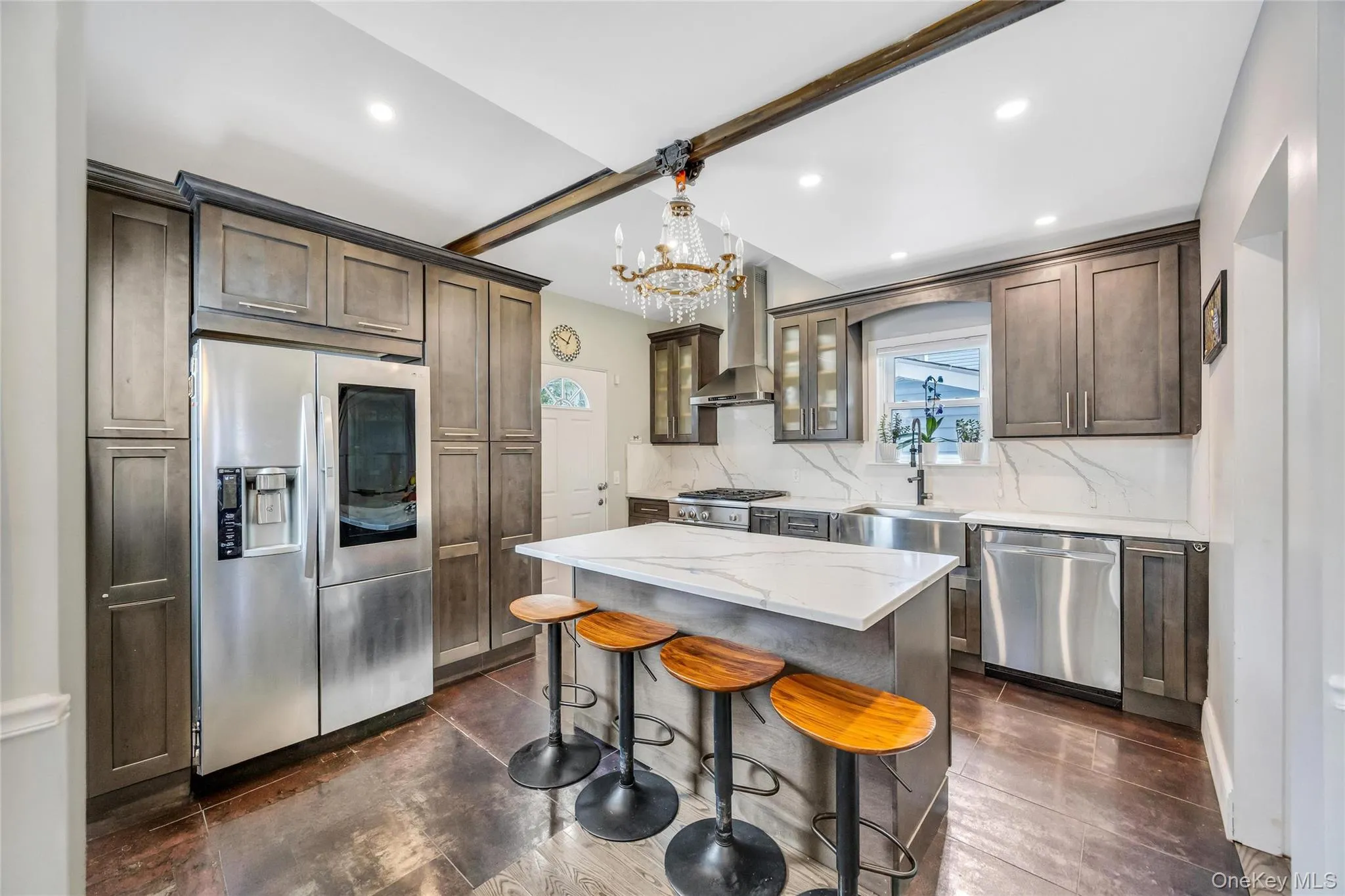 Kitchen featuring a central island with a solid surface countertop, wood-finish flooring, recessed lighting, and stainless steel appliances Kitchen featuring a central island with a solid surface countertop, wood-finish flooring, recessed lighting, and stainless steel appliances