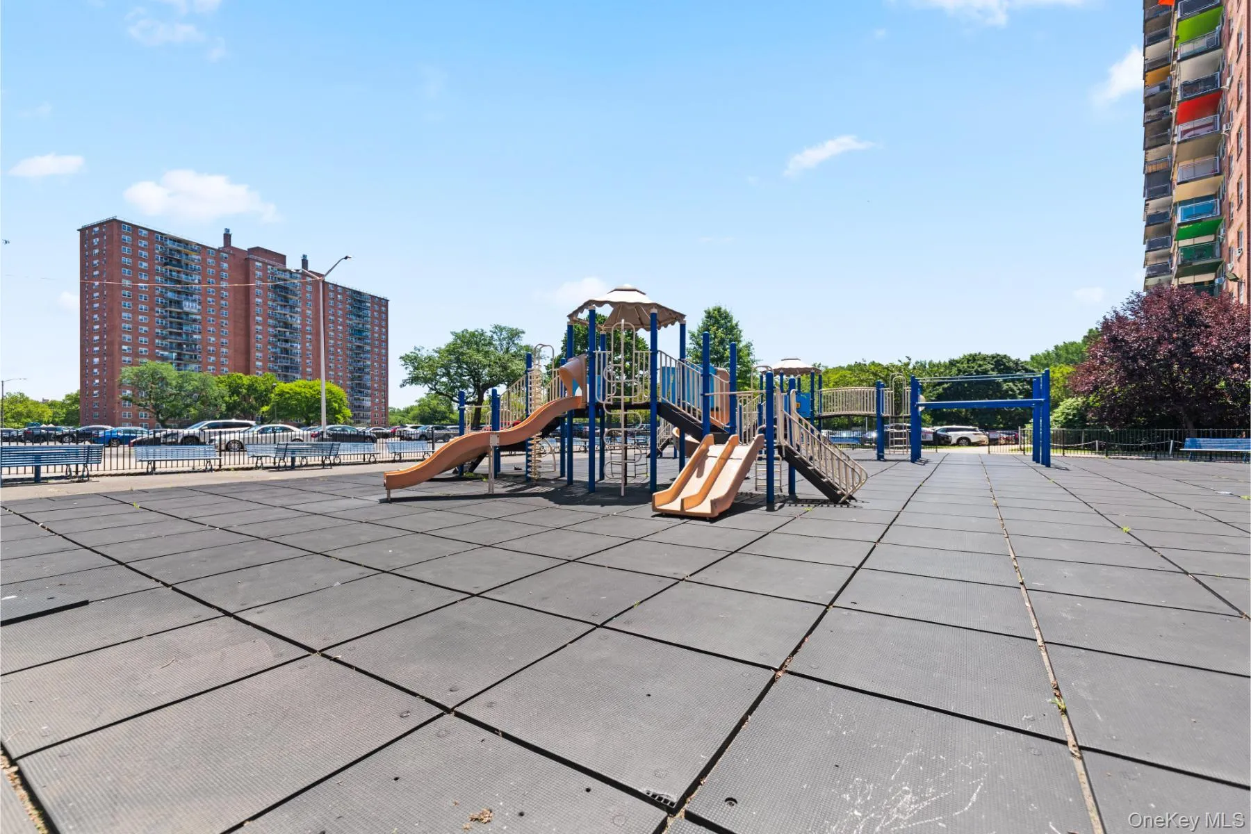 Outdoor recreational area featuring a multi-level playground structure with slides and climbing elements, set on a rubberized safety surface Outdoor recreational area featuring a multi-level playground structure with slides and climbing elements, set on a rubberized safety surface