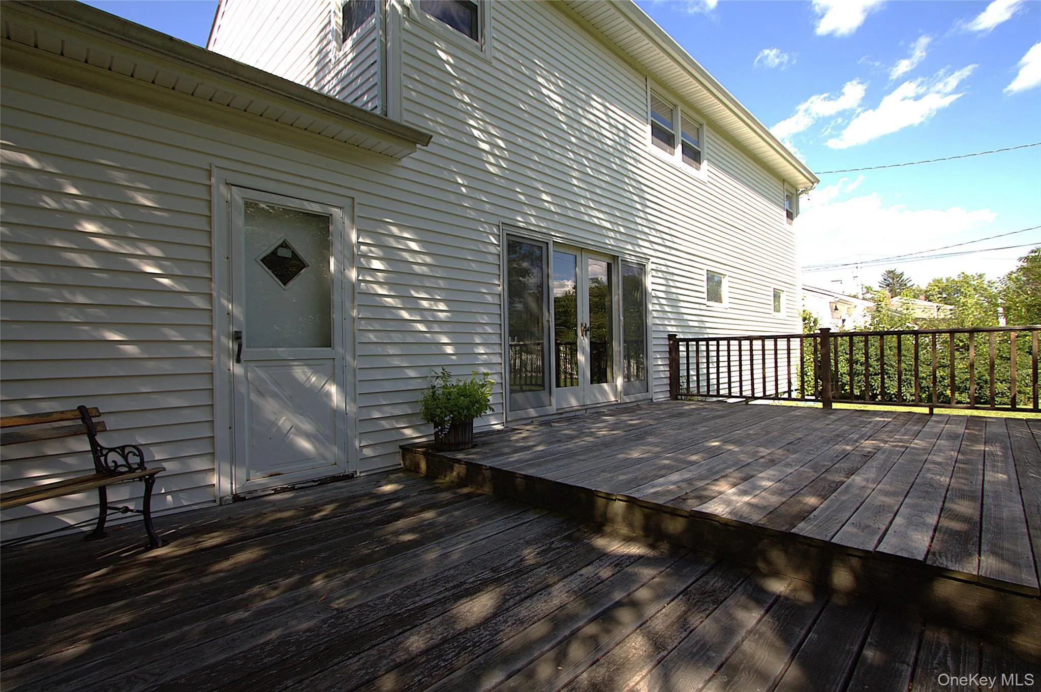 Expansive wood deck with wood railings, siding exterior, and sliding glass doors Expansive wood deck with wood railings, siding exterior, and sliding glass doors