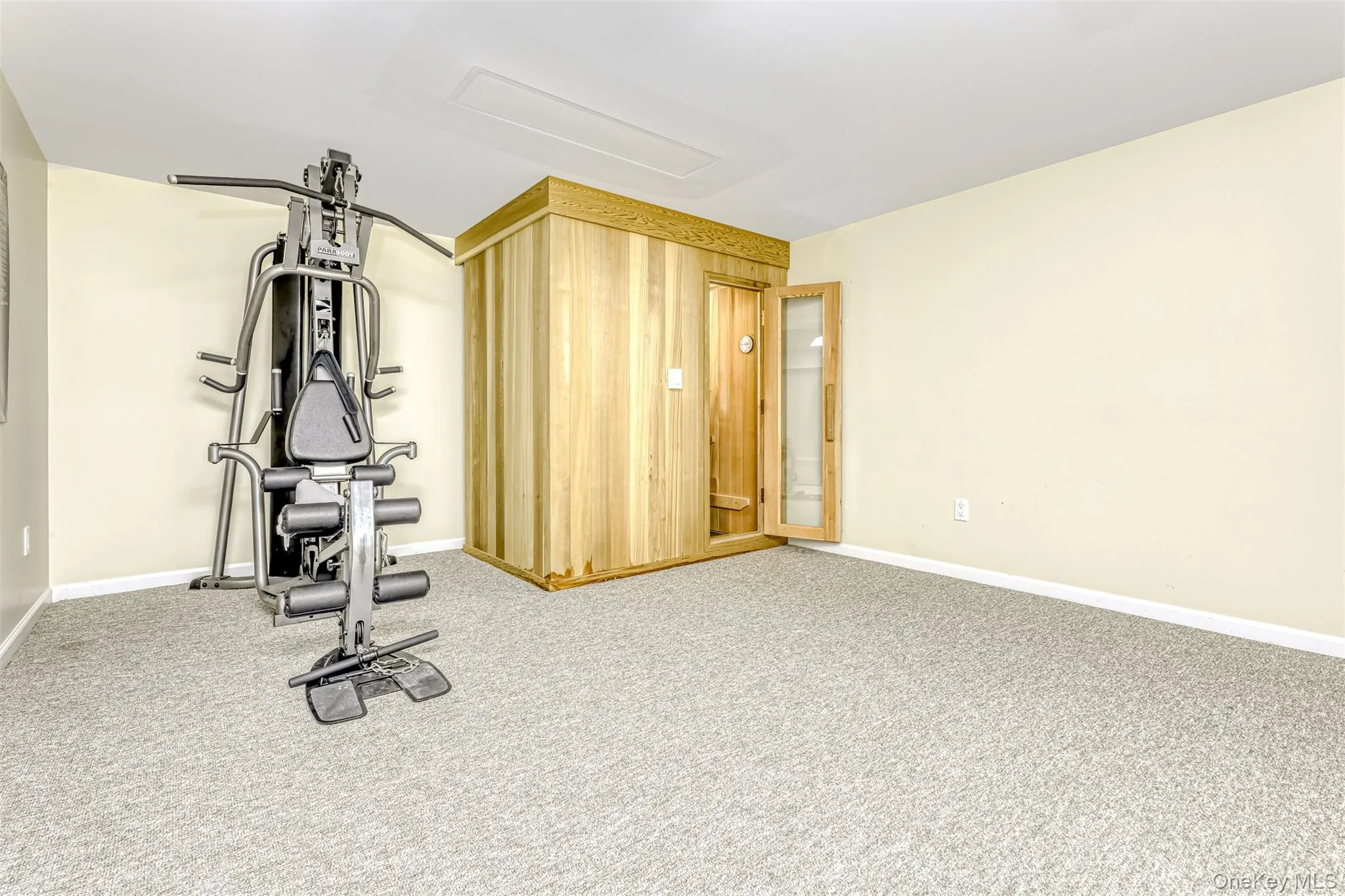 Dedicated space featuring a built-in wood sauna and light-colored carpet flooring Dedicated space featuring a built-in wood sauna and light-colored carpet flooring