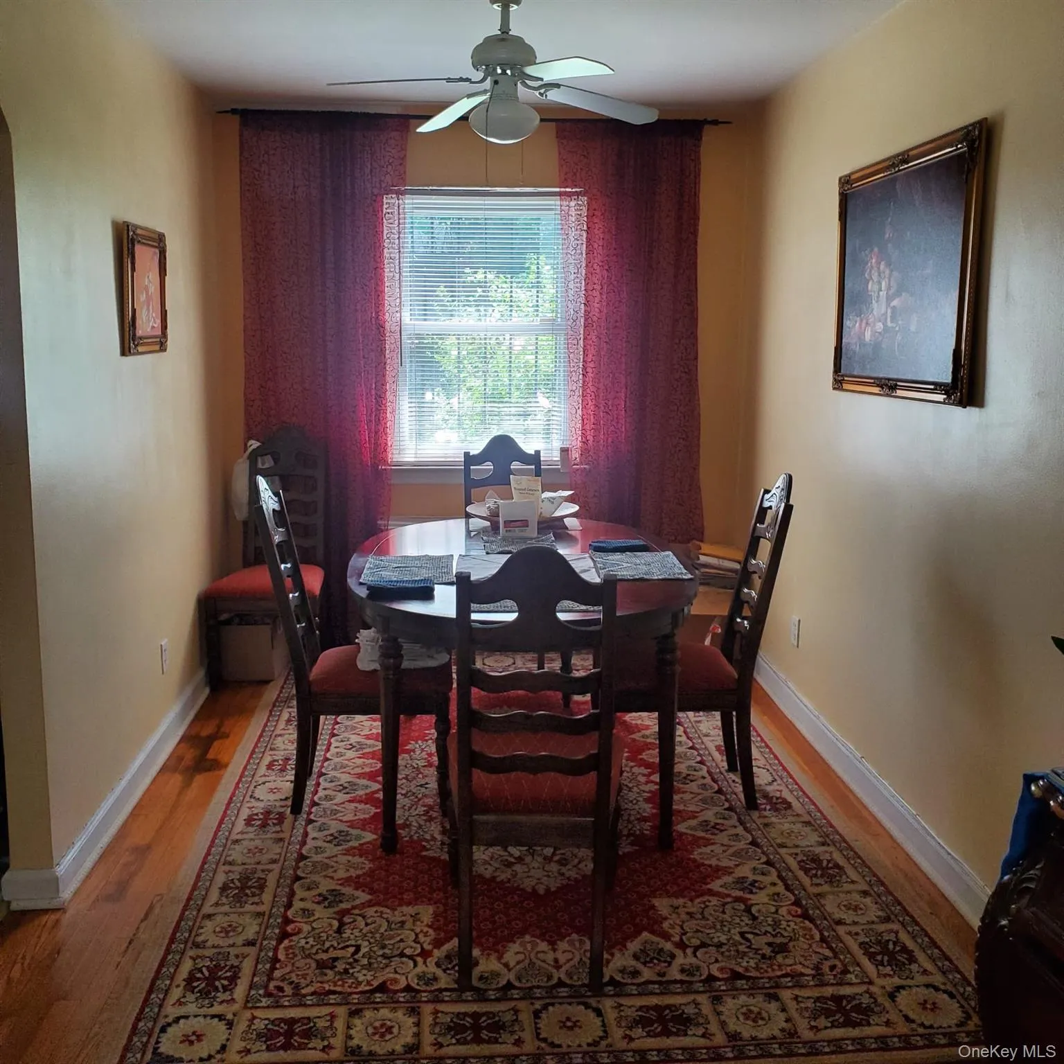 Dining area featuring wood-finish flooring, a window with blinds, and an overhead ceiling fan Dining area featuring wood-finish flooring, a window with blinds, and an overhead ceiling fan