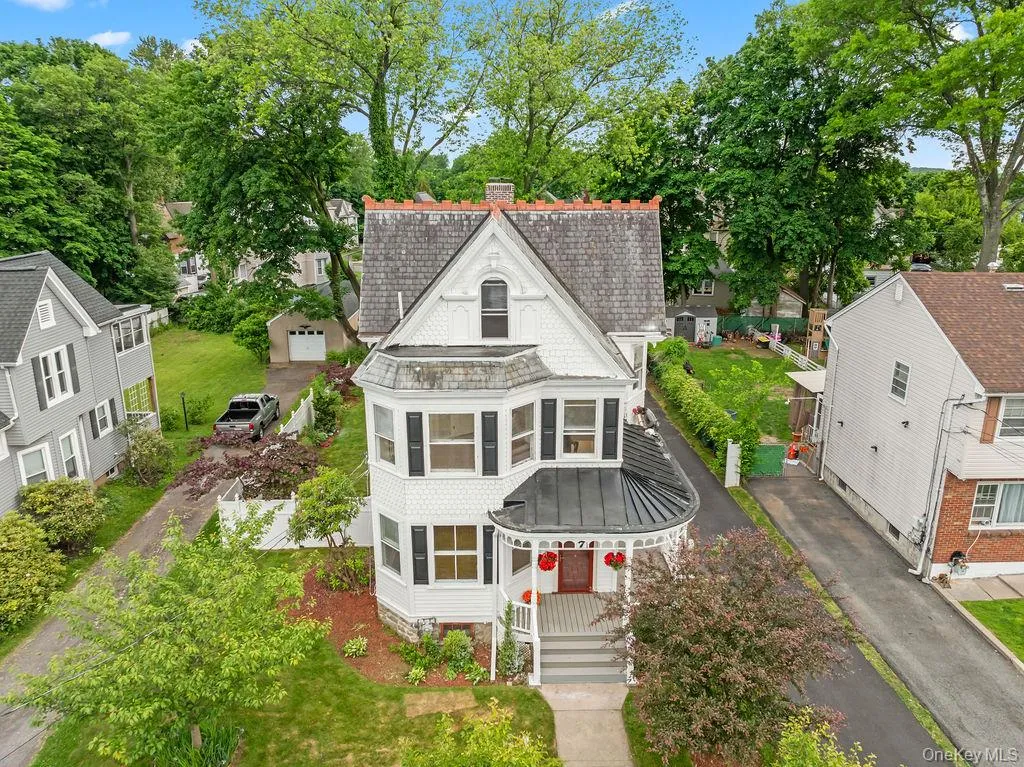Victorian-style residence featuring shingle siding, a wrap-around covered porch, and a dormer window Victorian-style residence featuring shingle siding, a wrap-around covered porch, and a dormer window