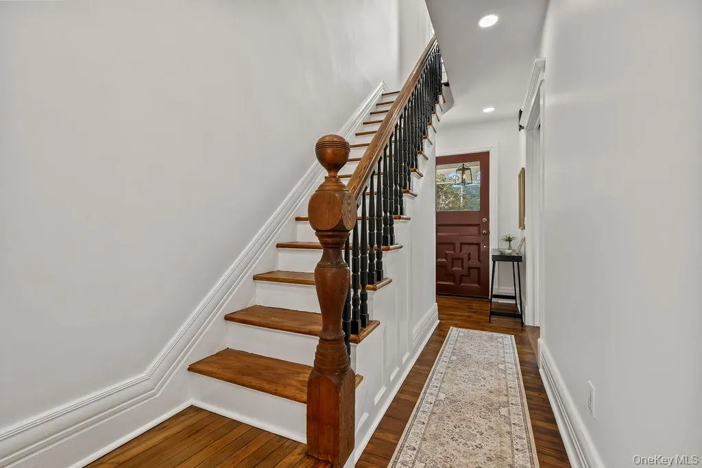 Hardwood staircase with turned balusters, hardwood flooring, recessed lighting, and a paneled entry door with glass inserts Hardwood staircase with turned balusters, hardwood flooring, recessed lighting, and a paneled entry door with glass inserts