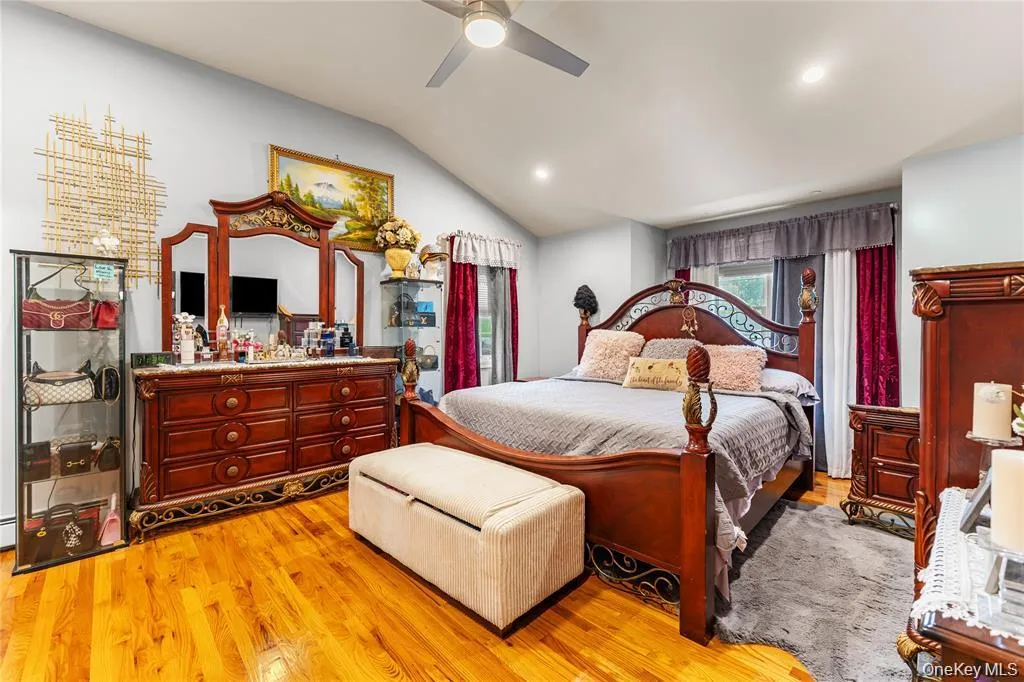 Bedroom featuring hardwood flooring, a vaulted ceiling with a ceiling fan, and recessed lighting Bedroom featuring hardwood flooring, a vaulted ceiling with a ceiling fan, and recessed lighting
