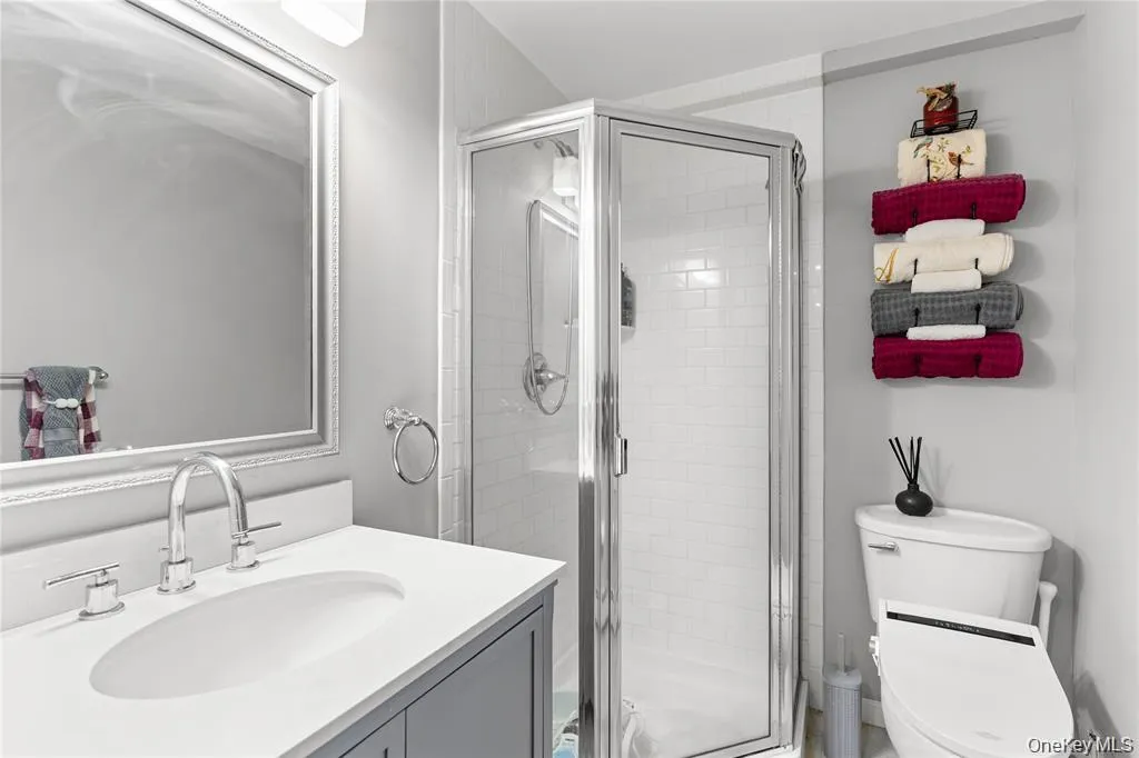 Modern bathroom featuring a single vanity with an integrated sink, chrome faucet, and framed mirror Modern bathroom featuring a single vanity with an integrated sink, chrome faucet, and framed mirror