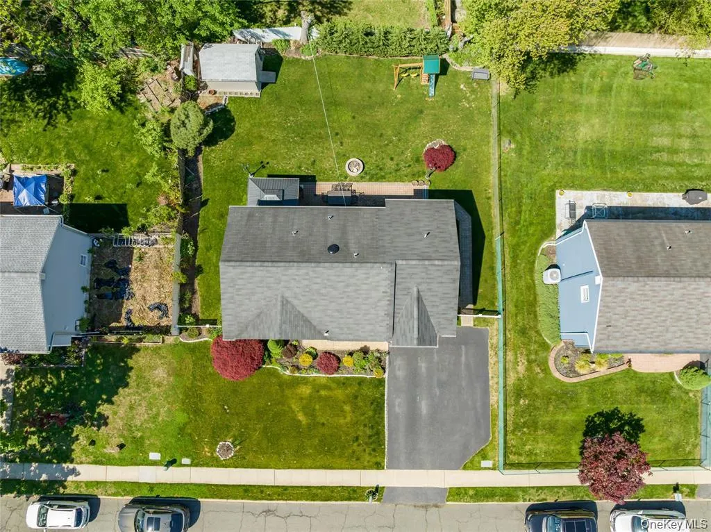 Expansive property featuring a gabled roofline, a paved driveway, and a large grassy backyard Expansive property featuring a gabled roofline, a paved driveway, and a large grassy backyard
