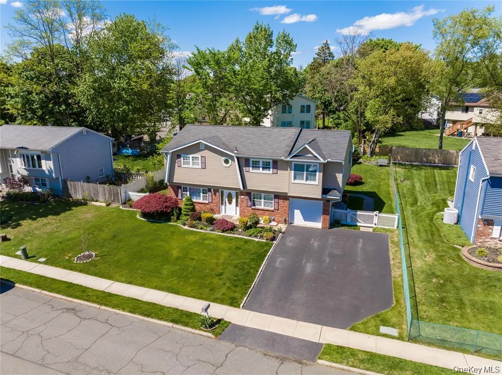 Two-story residence featuring a combination of brick and siding, an attached garage, and a paved driveway Two-story residence featuring a combination of brick and siding, an attached garage, and a paved driveway