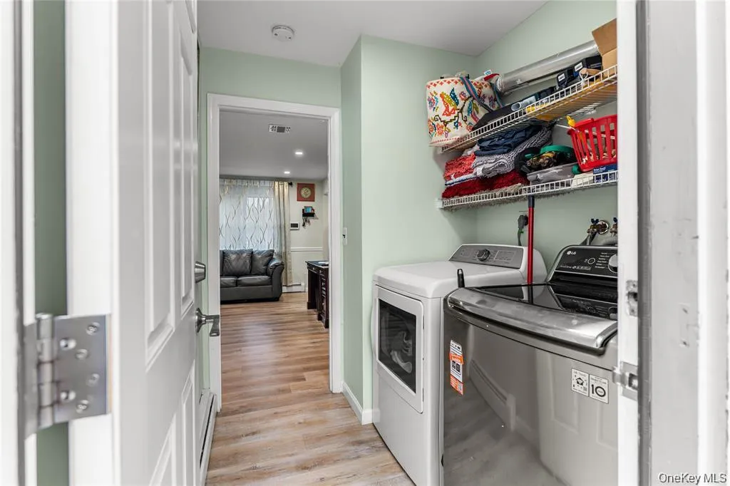Dedicated laundry area featuring a white dryer and a stainless steel washing machine Dedicated laundry area featuring a white dryer and a stainless steel washing machine