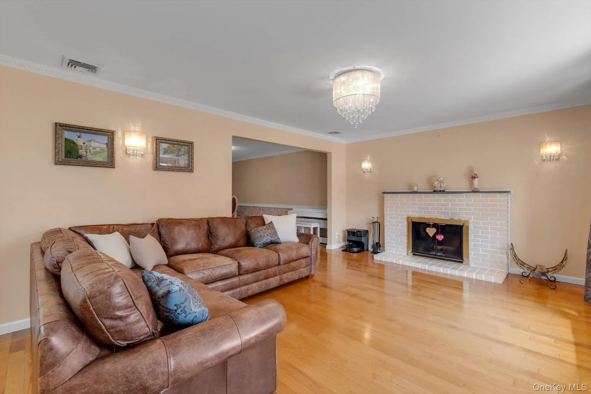 Living Room with wood burning fireplace, hardwood flooring, decorative wall paneling, crown molding, large window, and chandelier Living Room with wood burning fireplace, hardwood flooring, decorative wall paneling, crown molding, large window, and chandelier