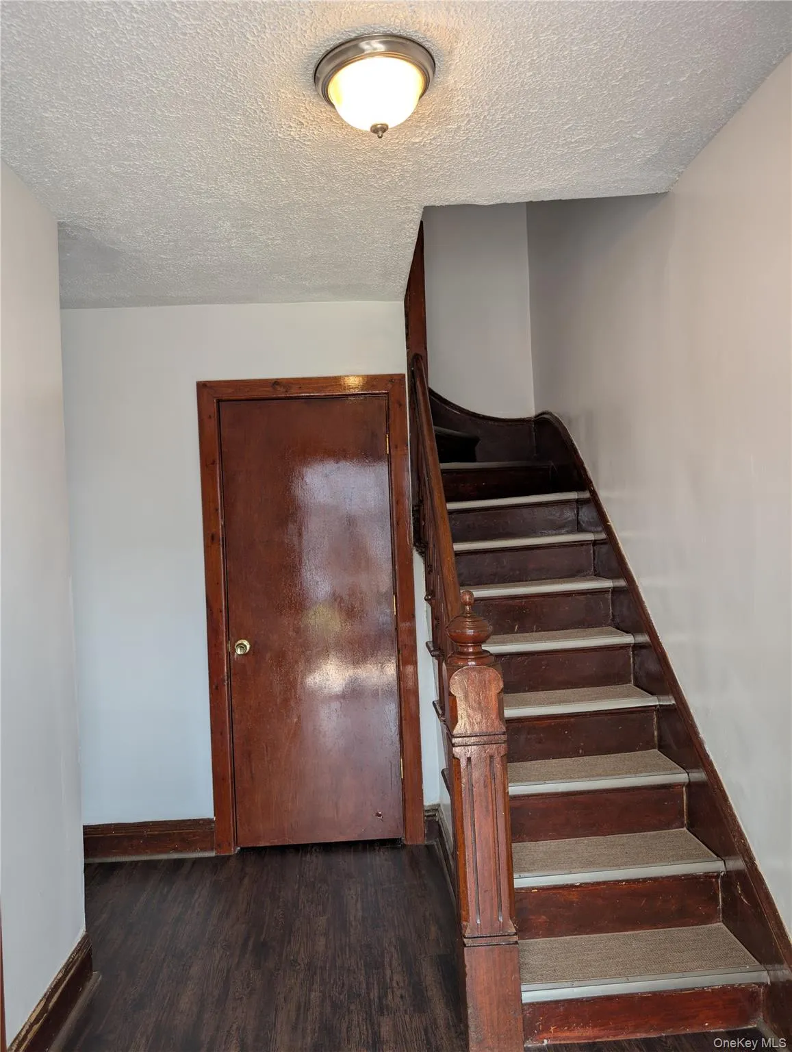 Entrance foyer with stairs to second story and entrance to living room Entrance foyer with stairs to second story and entrance to living room