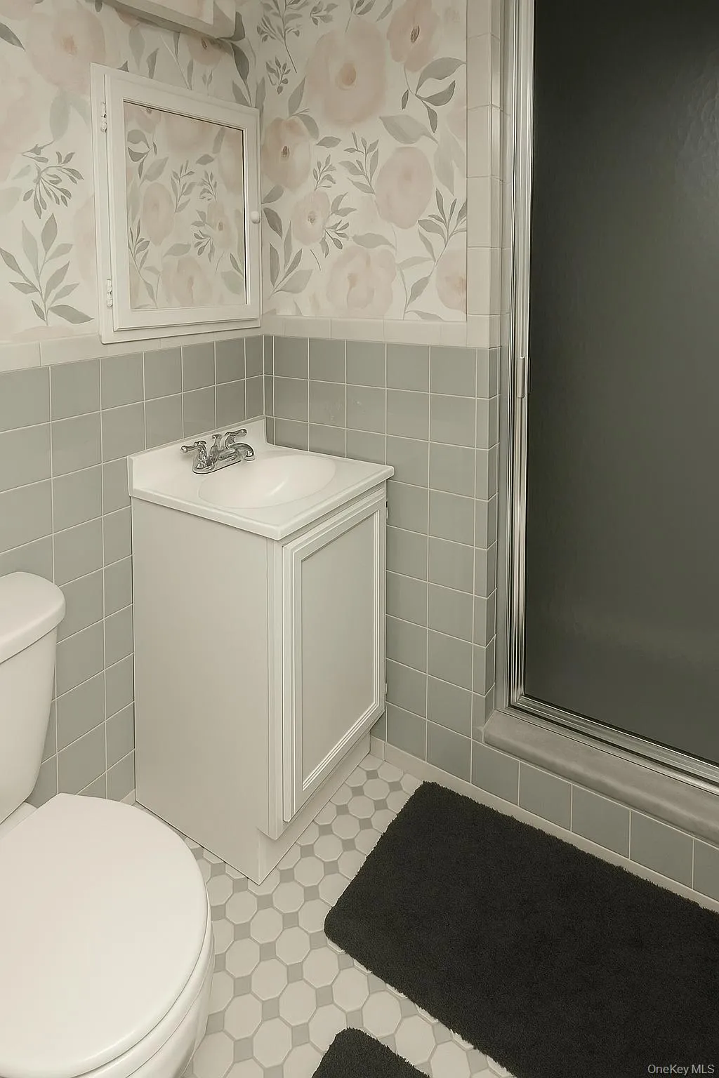 Bathroom with tile walls, vanity, tile patterned floors, a stall shower. Bathroom with tile walls, vanity, tile patterned floors, a stall shower.