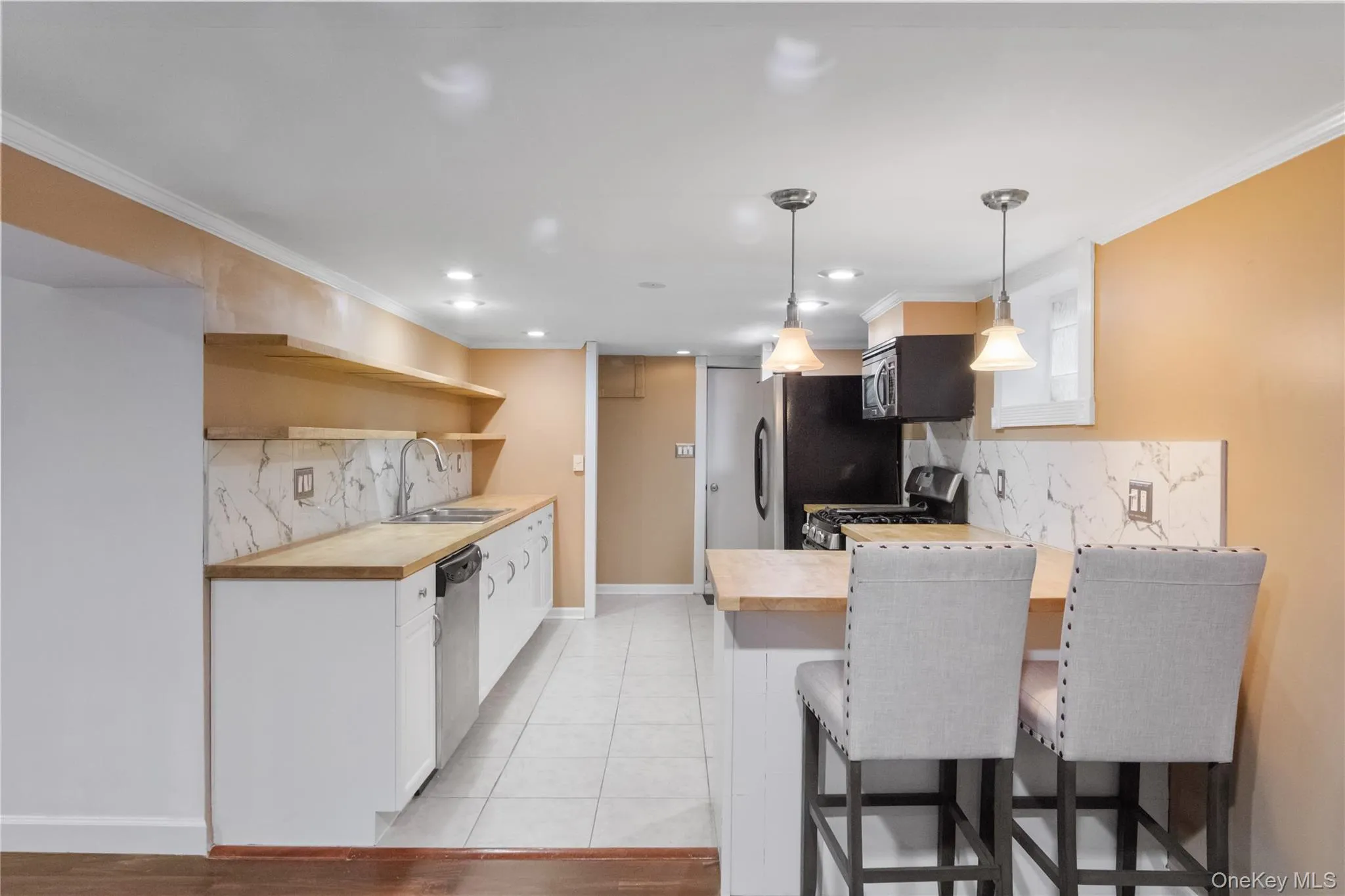 This bright and airy lower level kitchen features butcher block countertops and stainless steel appliances. This bright and airy lower level kitchen features butcher block countertops and stainless steel appliances.