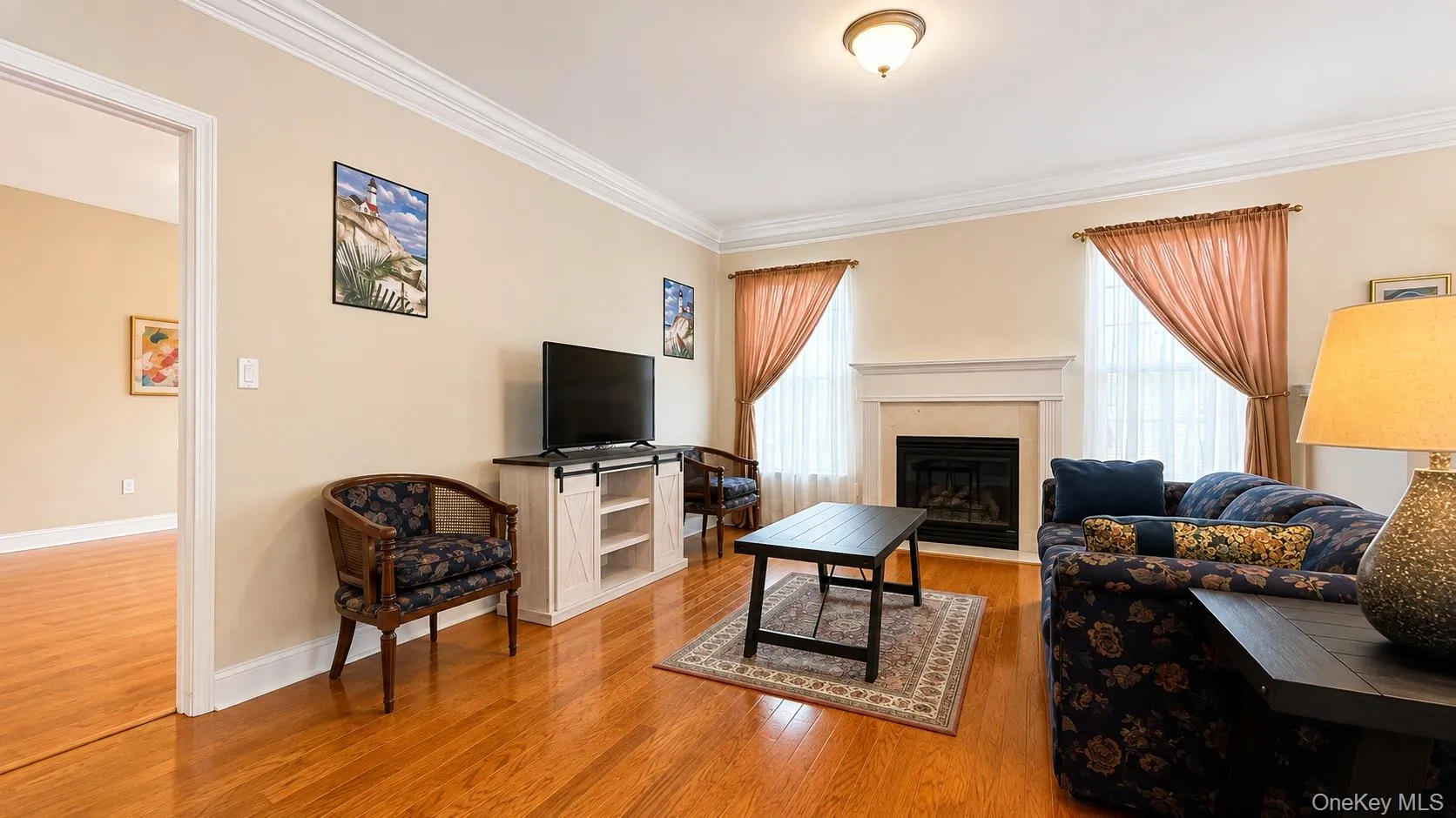 Wood-finish flooring, crown molding, fireplace with mantel, and recessed windows Wood-finish flooring, crown molding, fireplace with mantel, and recessed windows