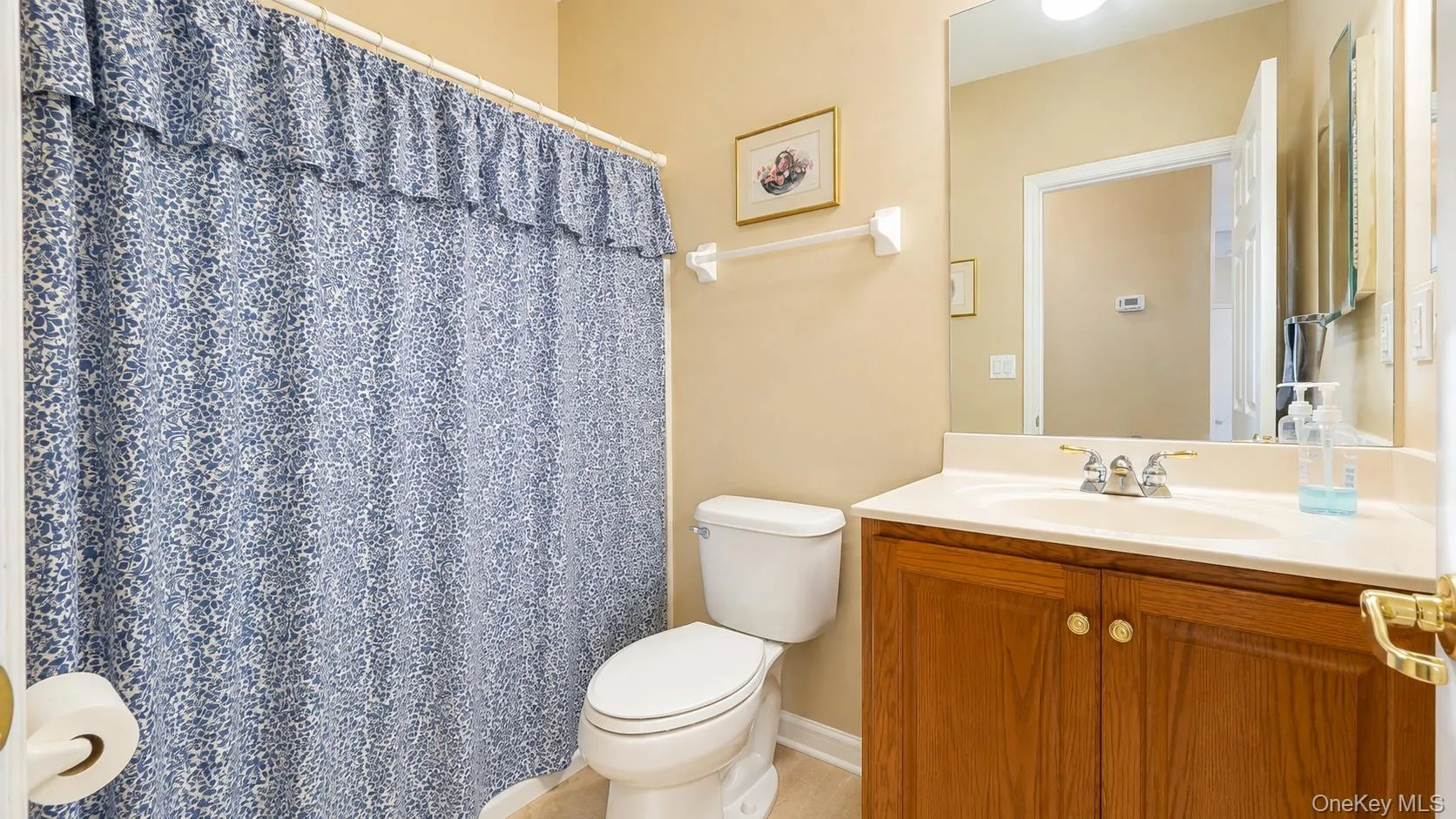 Built-in wood-finish vanity with a single basin sink and a large wall-mounted mirror Built-in wood-finish vanity with a single basin sink and a large wall-mounted mirror