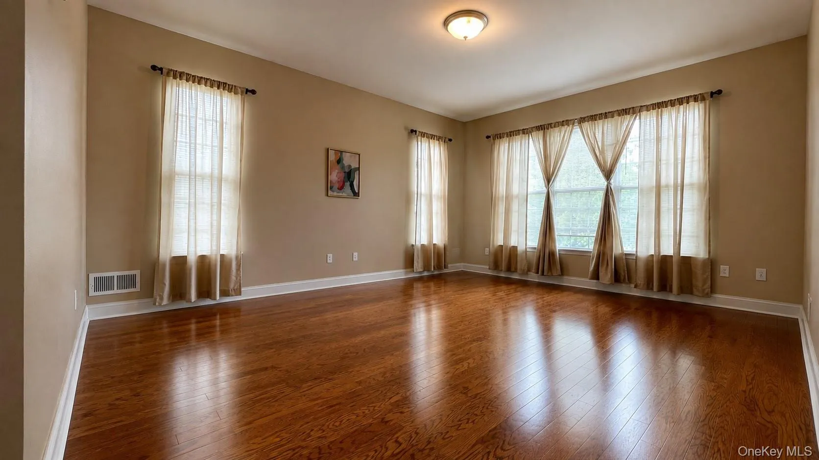 Hardwood-style flooring throughout, crown molding, and multiple large windows with drapes Hardwood-style flooring throughout, crown molding, and multiple large windows with drapes
