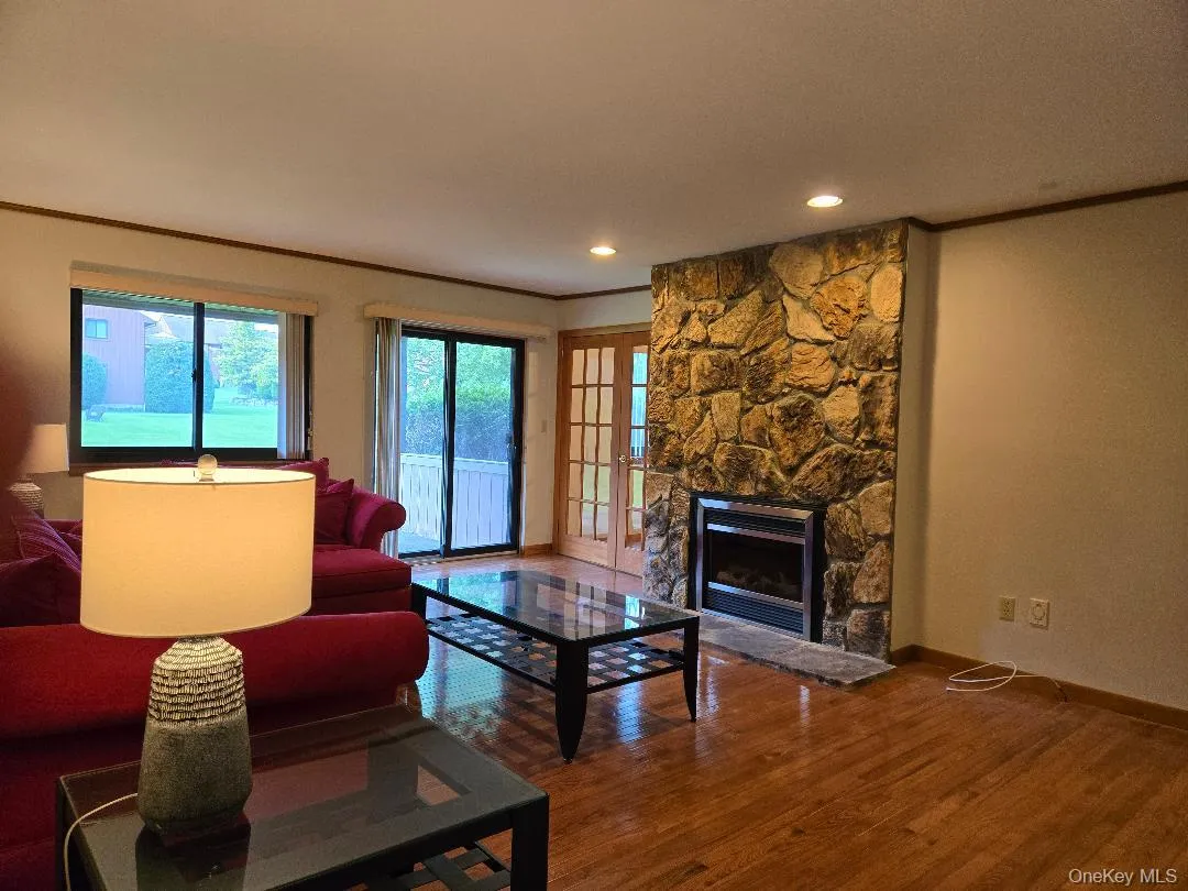 View of Living Room, featuring the beautiful Stone Gas Fplc, sliding glass door to the patio and door to the dining room. View of Living Room, featuring the beautiful Stone Gas Fplc, sliding glass door to the patio and door to the dining room.