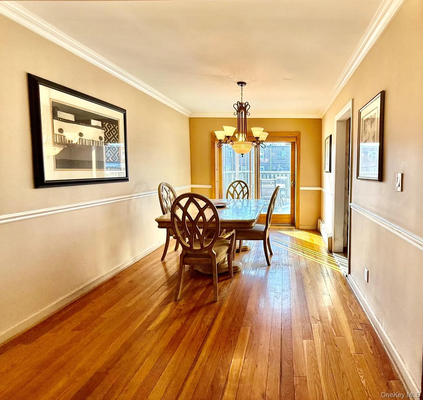 Hardwood flooring throughout, featuring a chair rail and crown molding Hardwood flooring throughout, featuring a chair rail and crown molding