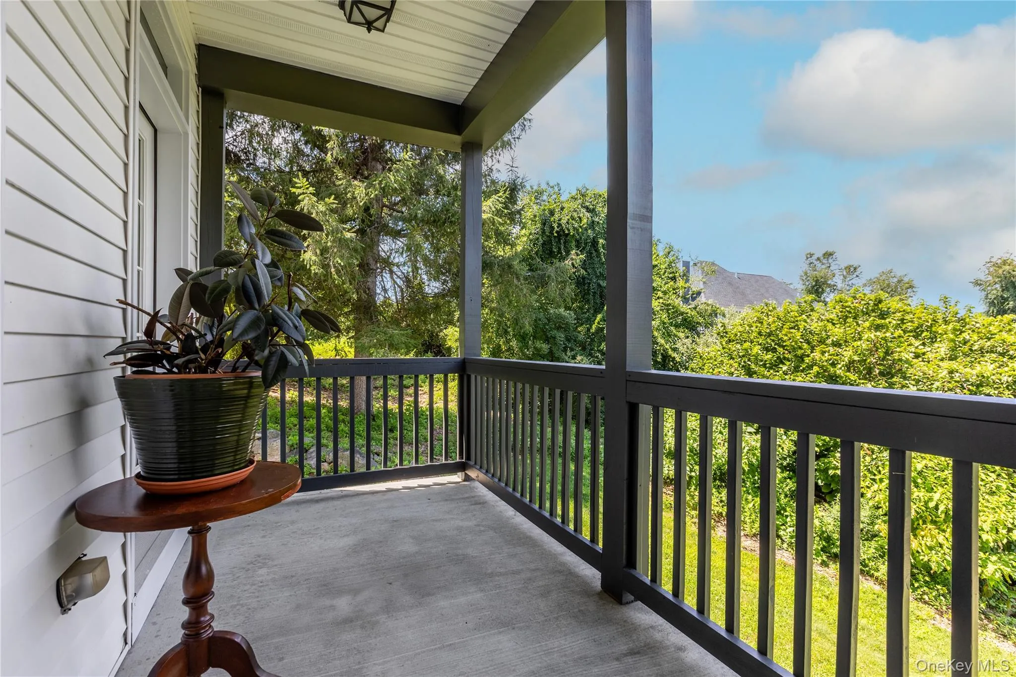 Covered porch with dark trim, ceiling-mounted light fixture Covered porch with dark trim, ceiling-mounted light fixture