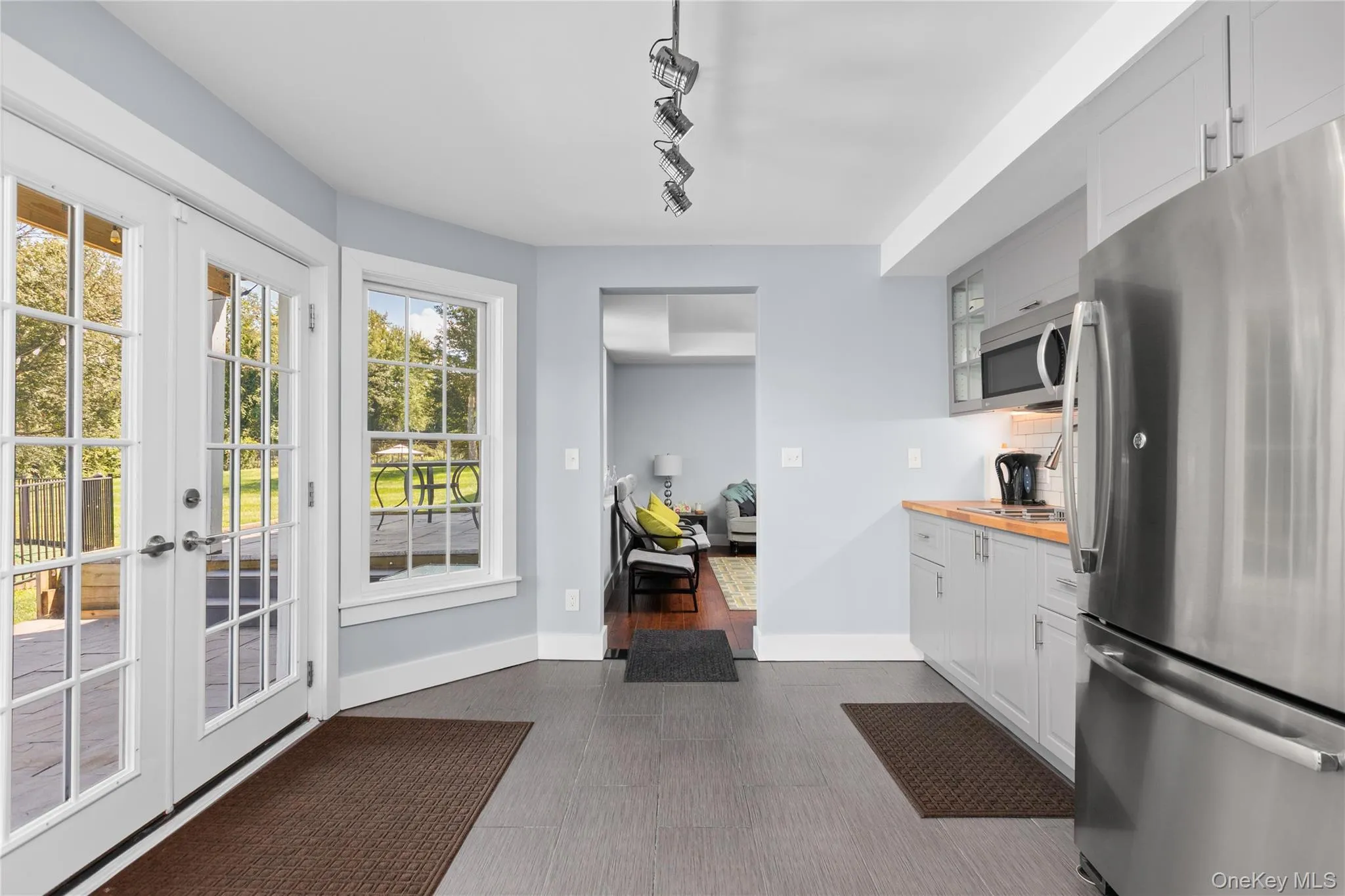 Double French doors, large window, hardwood flooring, stainless steel appliances, and contemporary cabinetry Double French doors, large window, hardwood flooring, stainless steel appliances, and contemporary cabinetry