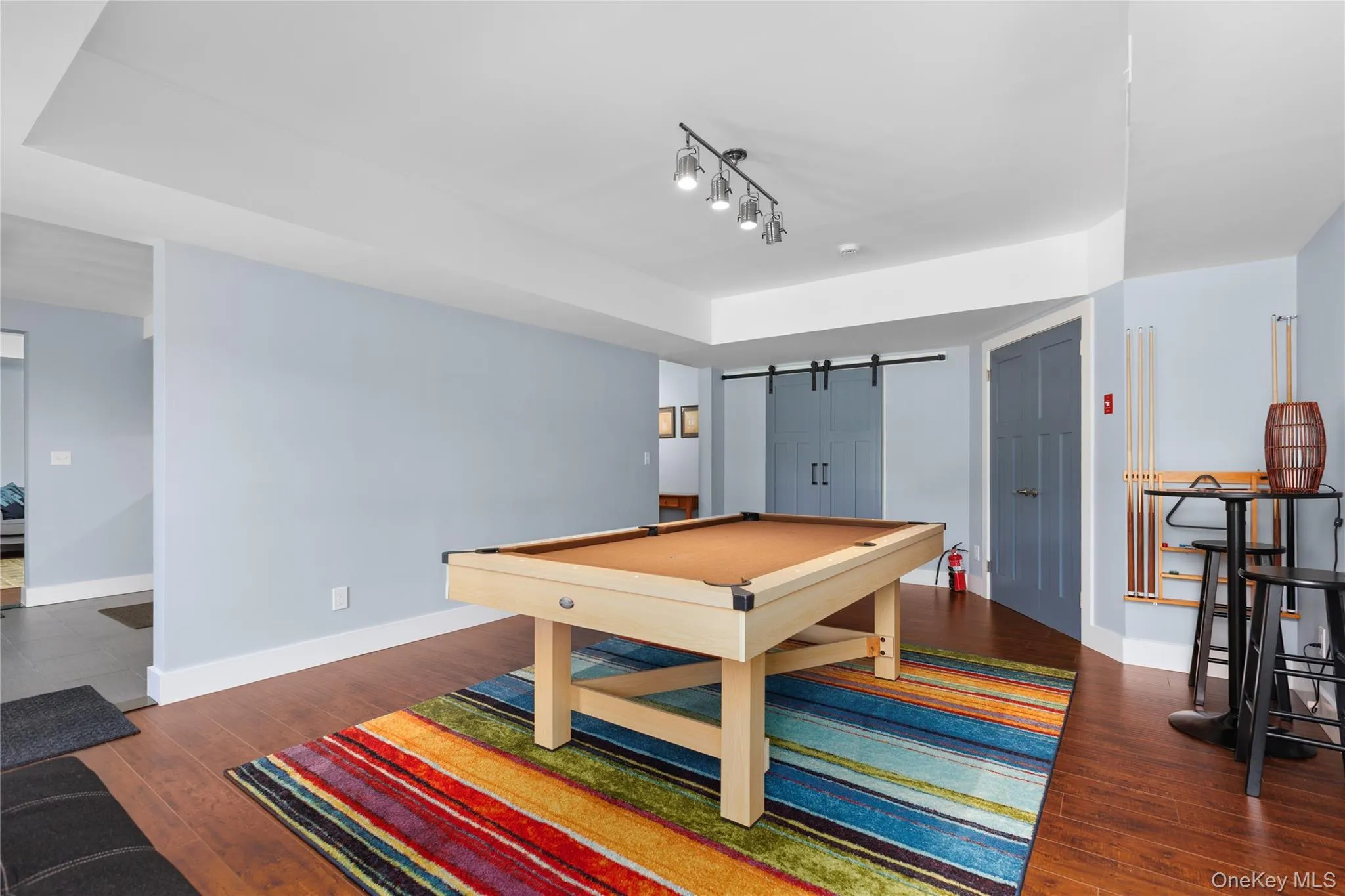 Recreation room featuring a regulation pool table with natural wood frame and felt playing surface, complemented by hardwood flooring throughout Recreation room featuring a regulation pool table with natural wood frame and felt playing surface, complemented by hardwood flooring throughout