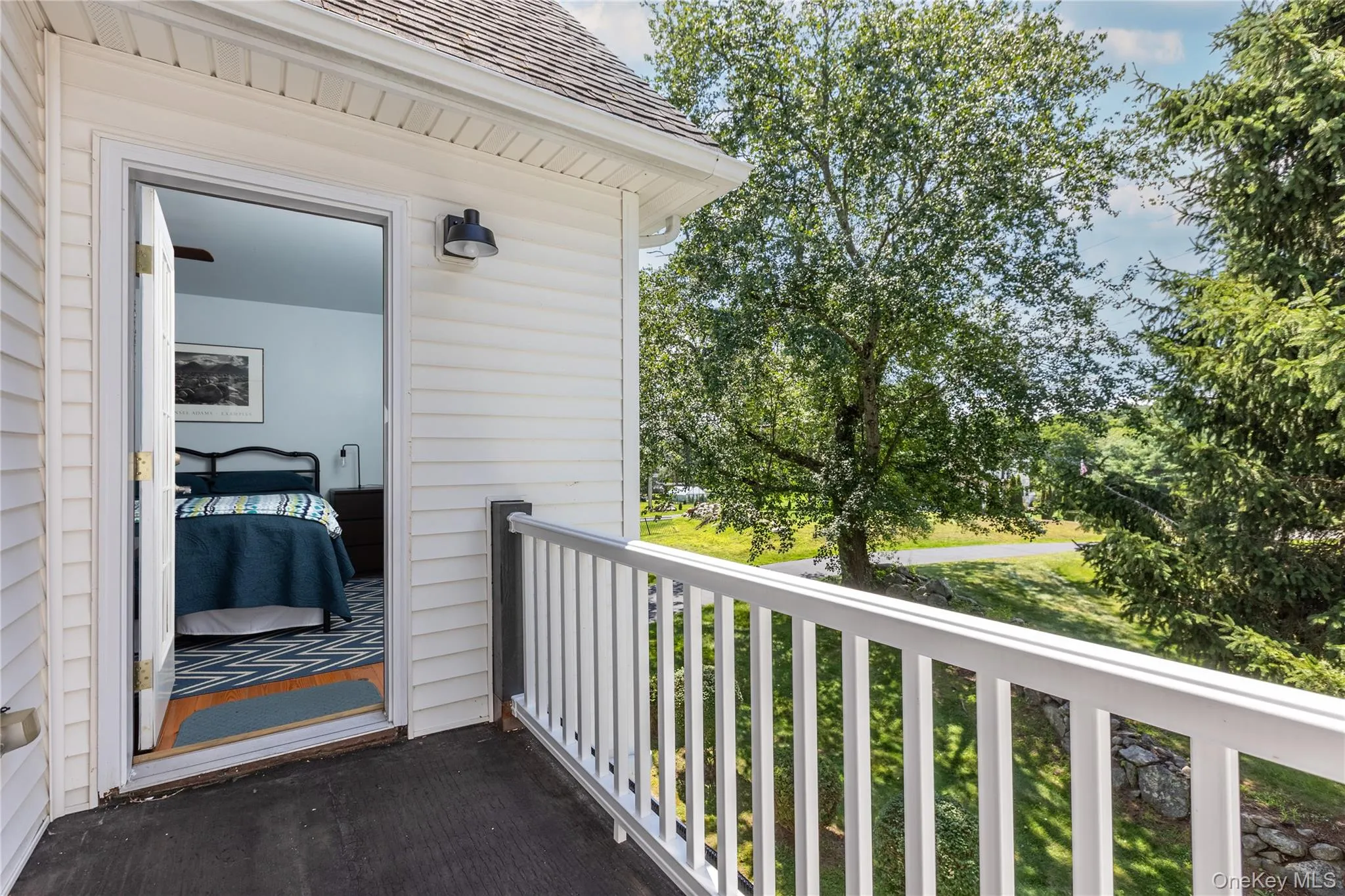 Exterior balcony featuring white railing, dark flooring, and access to an interior room. Exterior balcony featuring white railing, dark flooring, and access to an interior room.