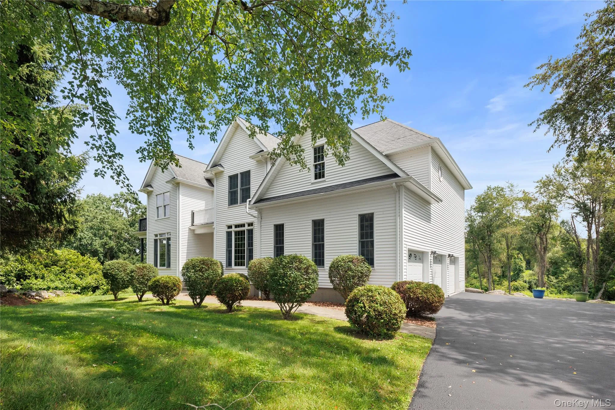 Elegant Colonial-style residence featuring a clean white exterior with multi-gable roofline, and architectural detail. Elegant Colonial-style residence featuring a clean white exterior with multi-gable roofline, and architectural detail.