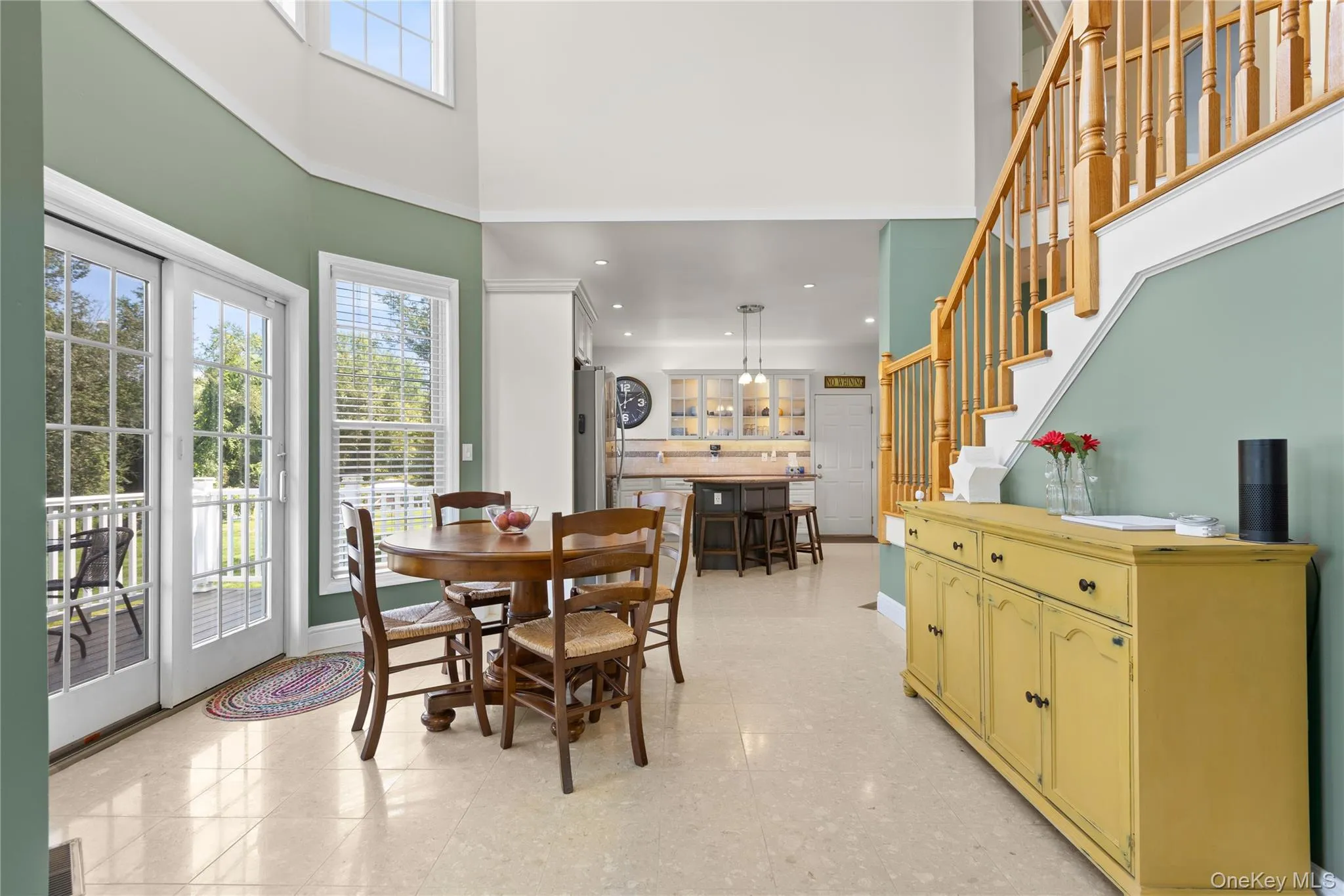 Eat in kitchen featuring natural wood balusters, a built-in staircase, and a cream tile floor Eat in kitchen featuring natural wood balusters, a built-in staircase, and a cream tile floor