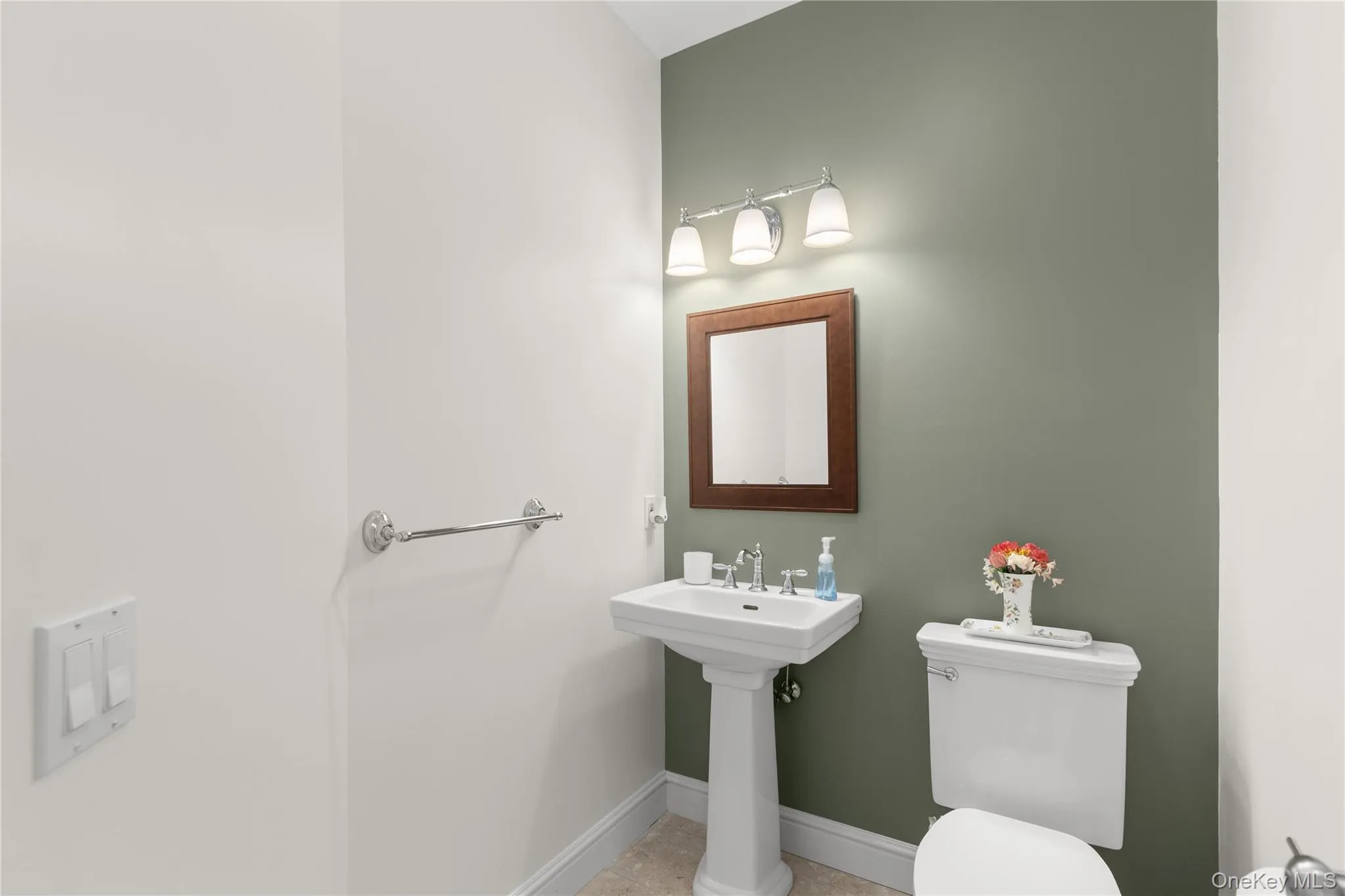 Half bathroom pedestal sink, mounted mirror, wall-mounted light fixture, and toilet Half bathroom pedestal sink, mounted mirror, wall-mounted light fixture, and toilet