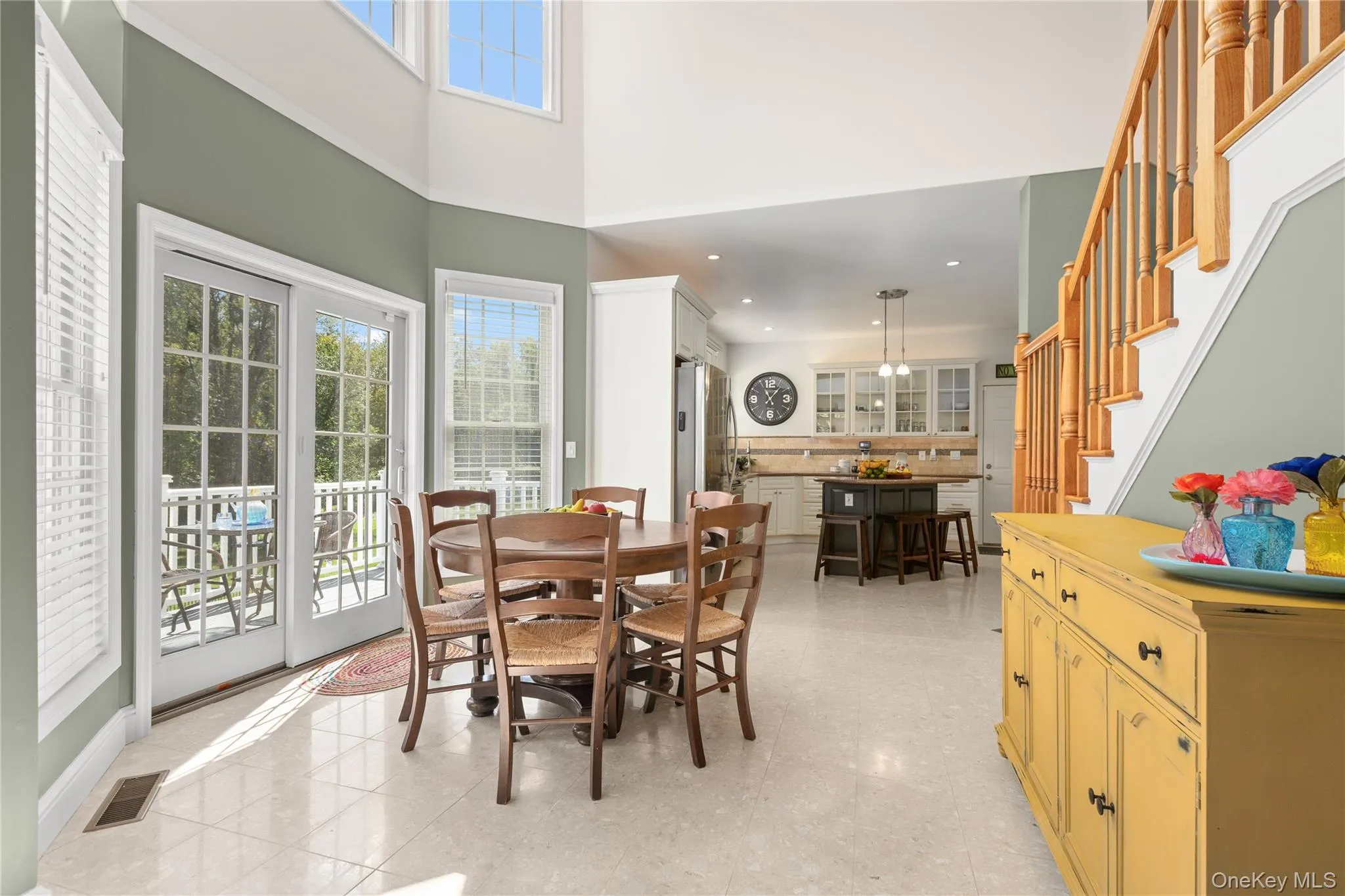 Eat in kitchen featuring natural wood balusters, a built-in staircase, and a cream tile floor Eat in kitchen featuring natural wood balusters, a built-in staircase, and a cream tile floor