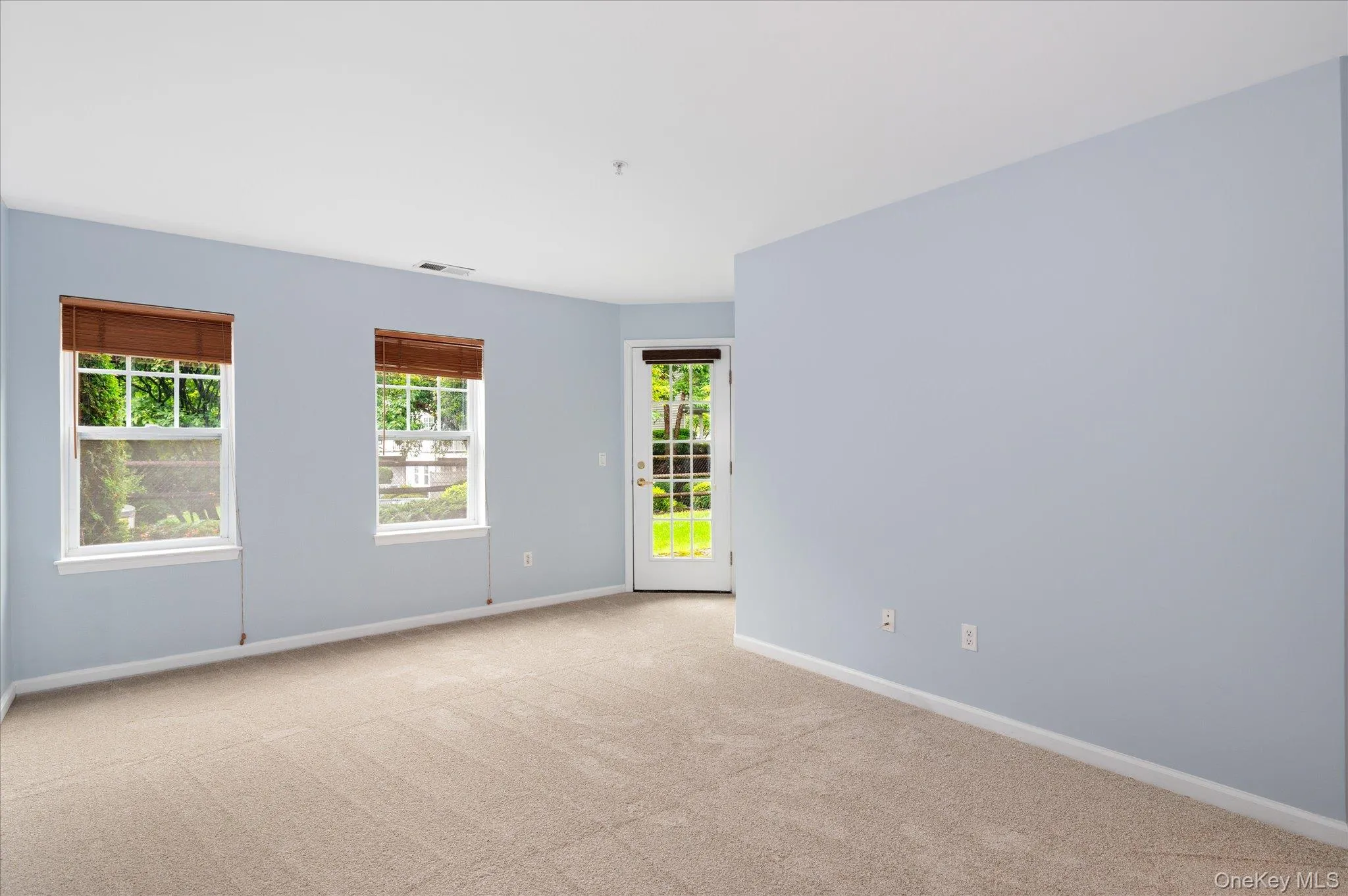 Spacious primary bedroom showing door leading to private outdoor patio - your own private oasis Spacious primary bedroom showing door leading to private outdoor patio - your own private oasis