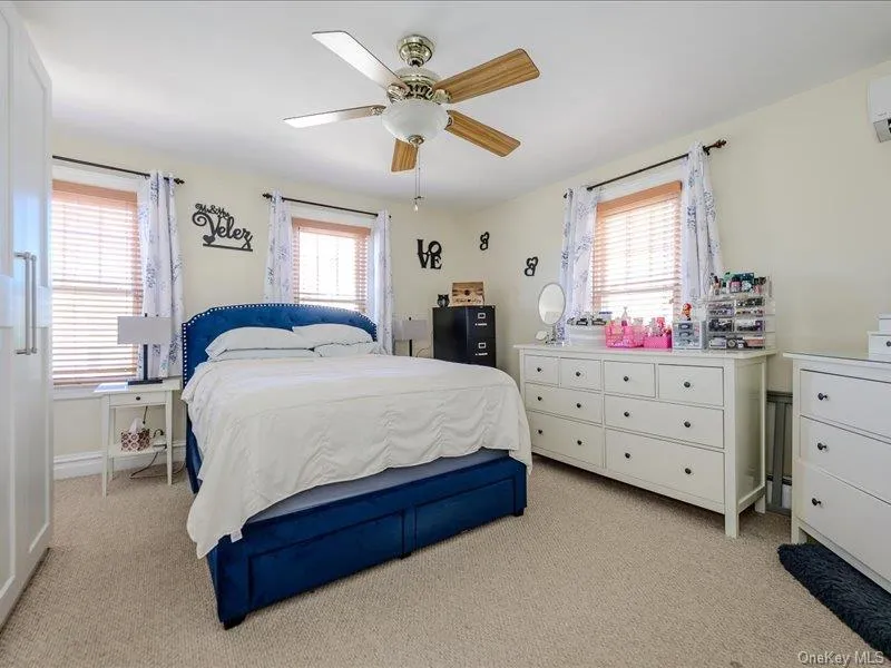 Master Bedroom featuring light-colored wall paint, two windows with wood blinds and curtain rods, and a ceiling fan with light fixture Master Bedroom featuring light-colored wall paint, two windows with wood blinds and curtain rods, and a ceiling fan with light fixture