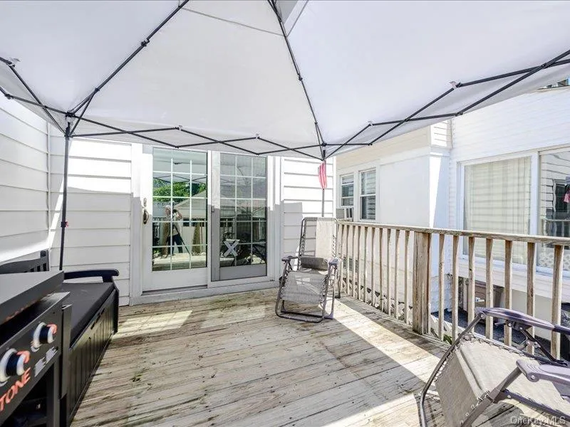 Expansive wooden deck with a white tent Expansive wooden deck with a white tent