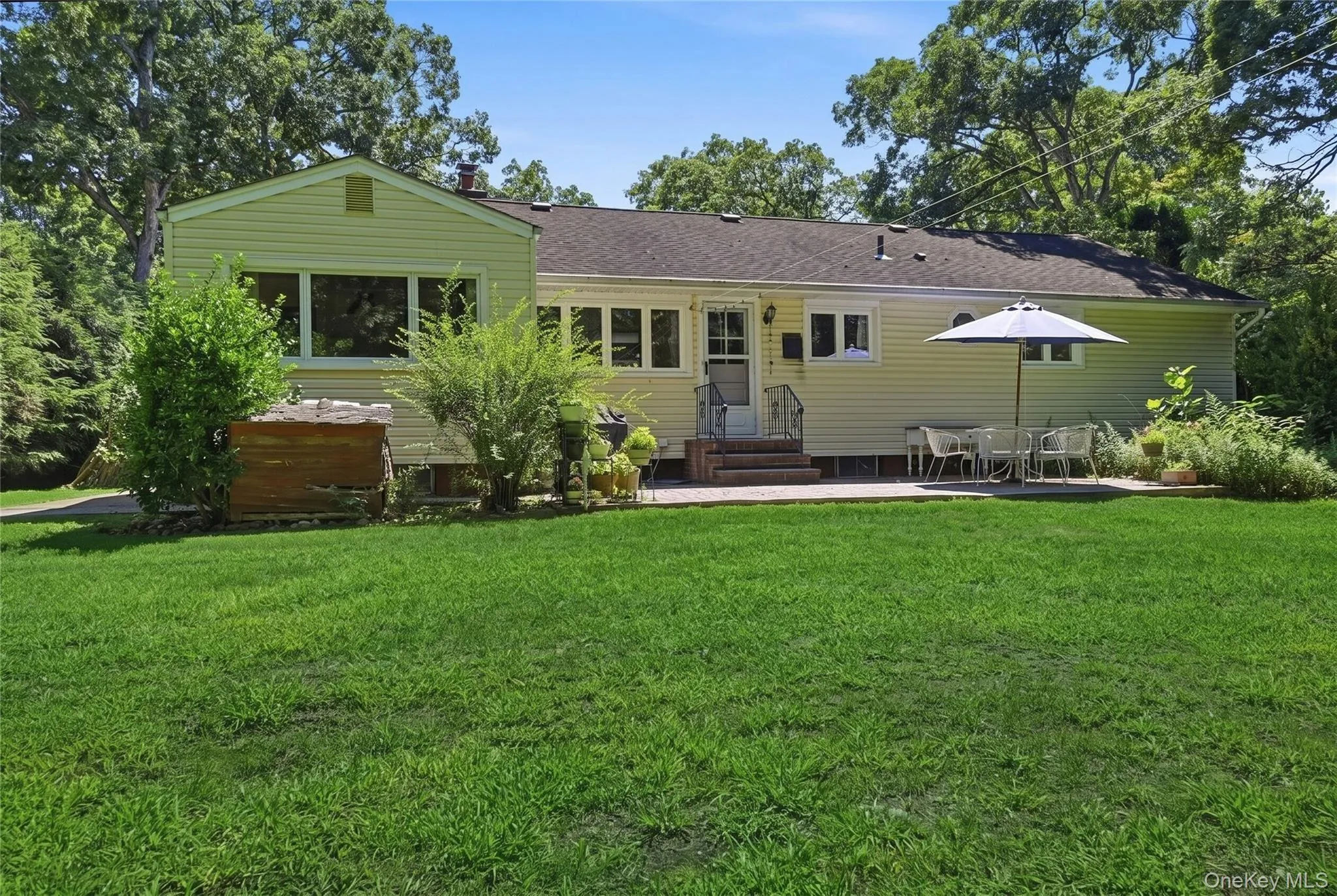 Back of house featuring brick patio and entrance to kitchen Back of house featuring brick patio and entrance to kitchen