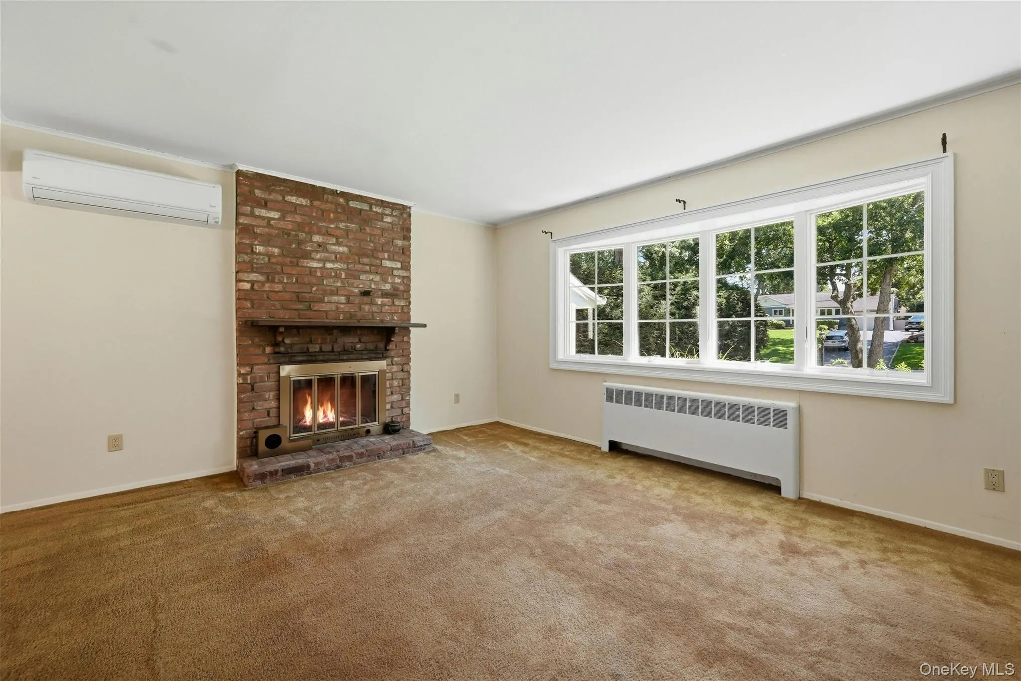 Large living room with wood burning fireplace and hardwood floors under carpet Large living room with wood burning fireplace and hardwood floors under carpet