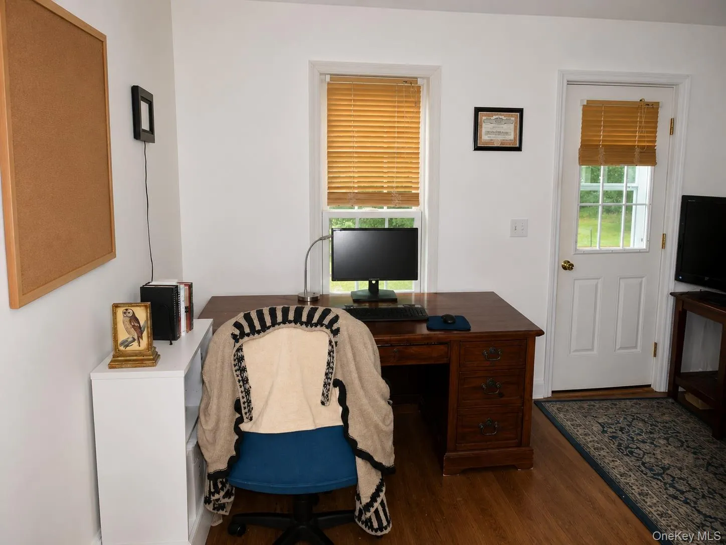Interior office space featuring wood-finish flooring and white walls Interior office space featuring wood-finish flooring and white walls