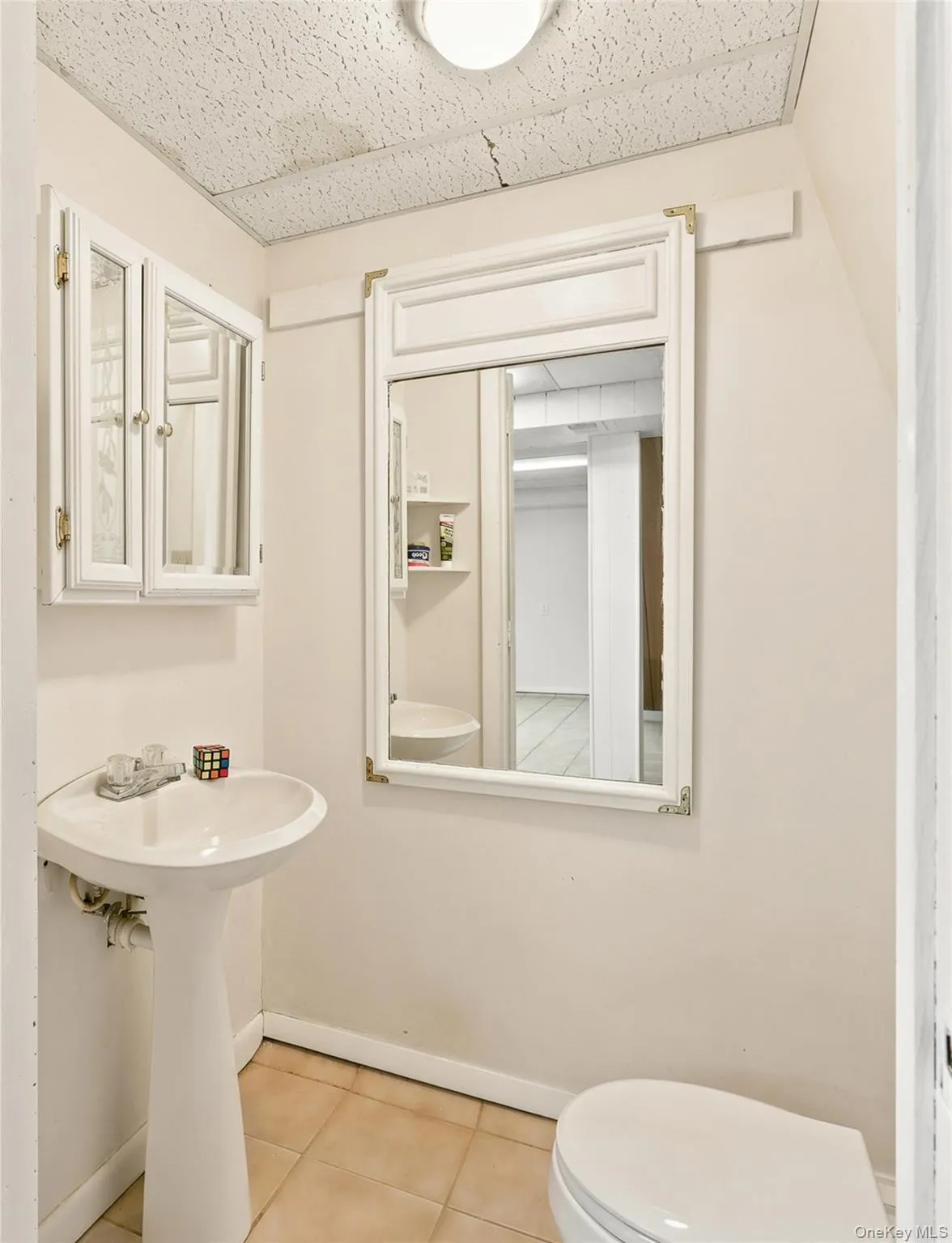 Pedestal sink with white basin, framed wall mirror, and built-in medicine cabinet with mirrored doors Pedestal sink with white basin, framed wall mirror, and built-in medicine cabinet with mirrored doors