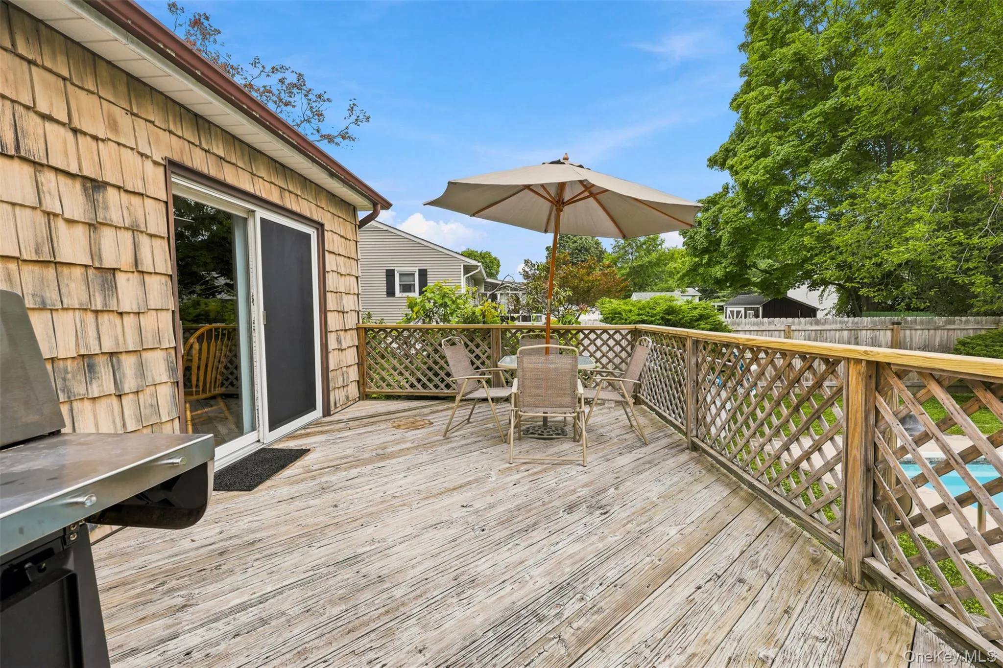 Spacious outdoor deck featuring wood flooring and lattice railing Spacious outdoor deck featuring wood flooring and lattice railing