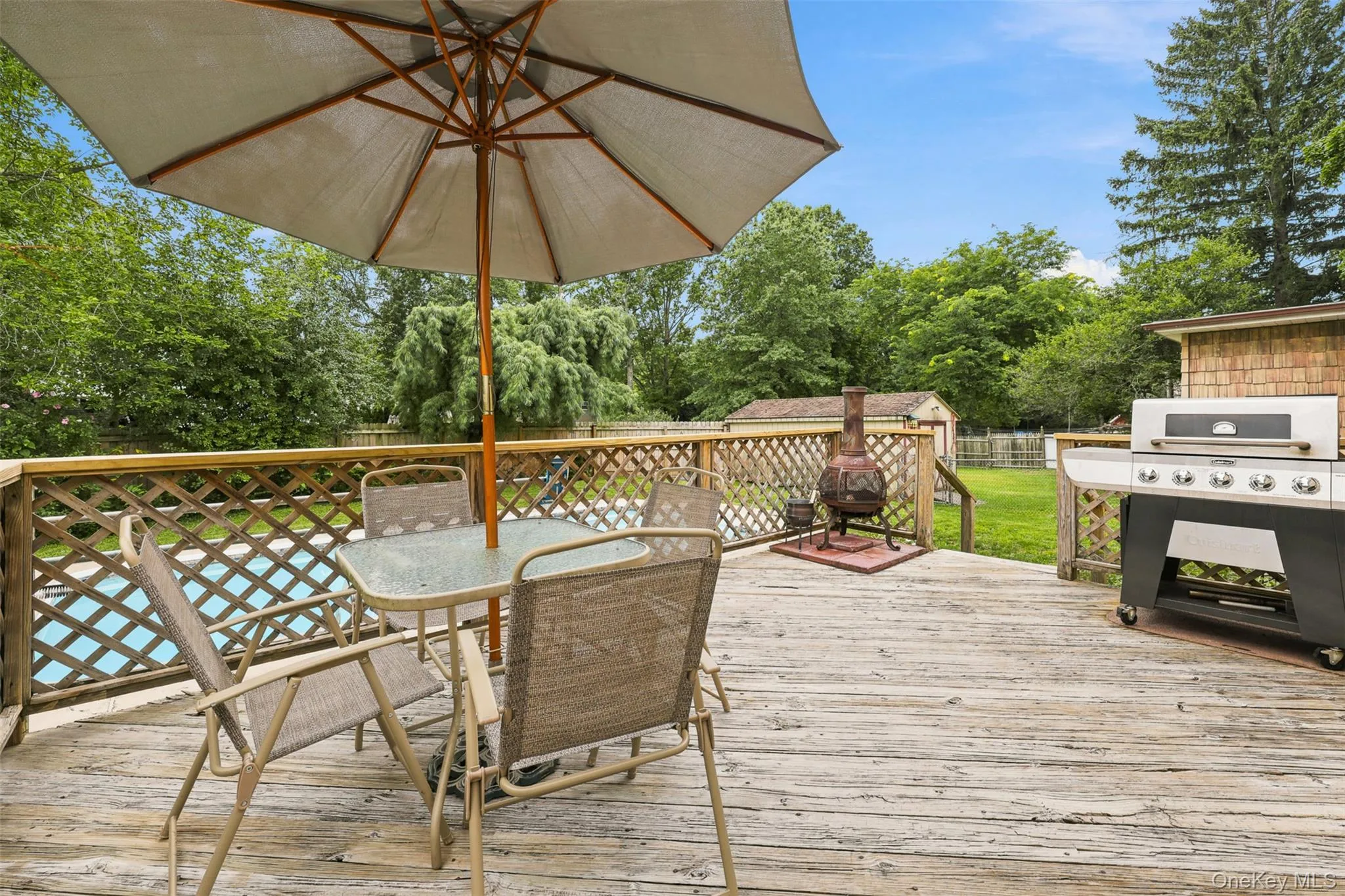 Expansive outdoor deck featuring wood-finish decking and lattice railing Expansive outdoor deck featuring wood-finish decking and lattice railing