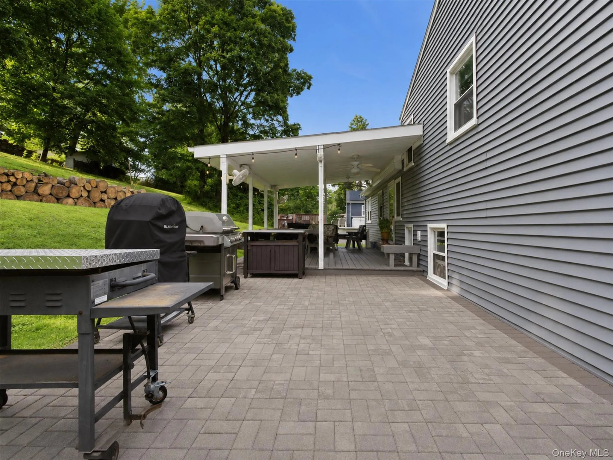 Expansive paver patio with a covered deck featuring recessed lighting and ceiling fans Expansive paver patio with a covered deck featuring recessed lighting and ceiling fans