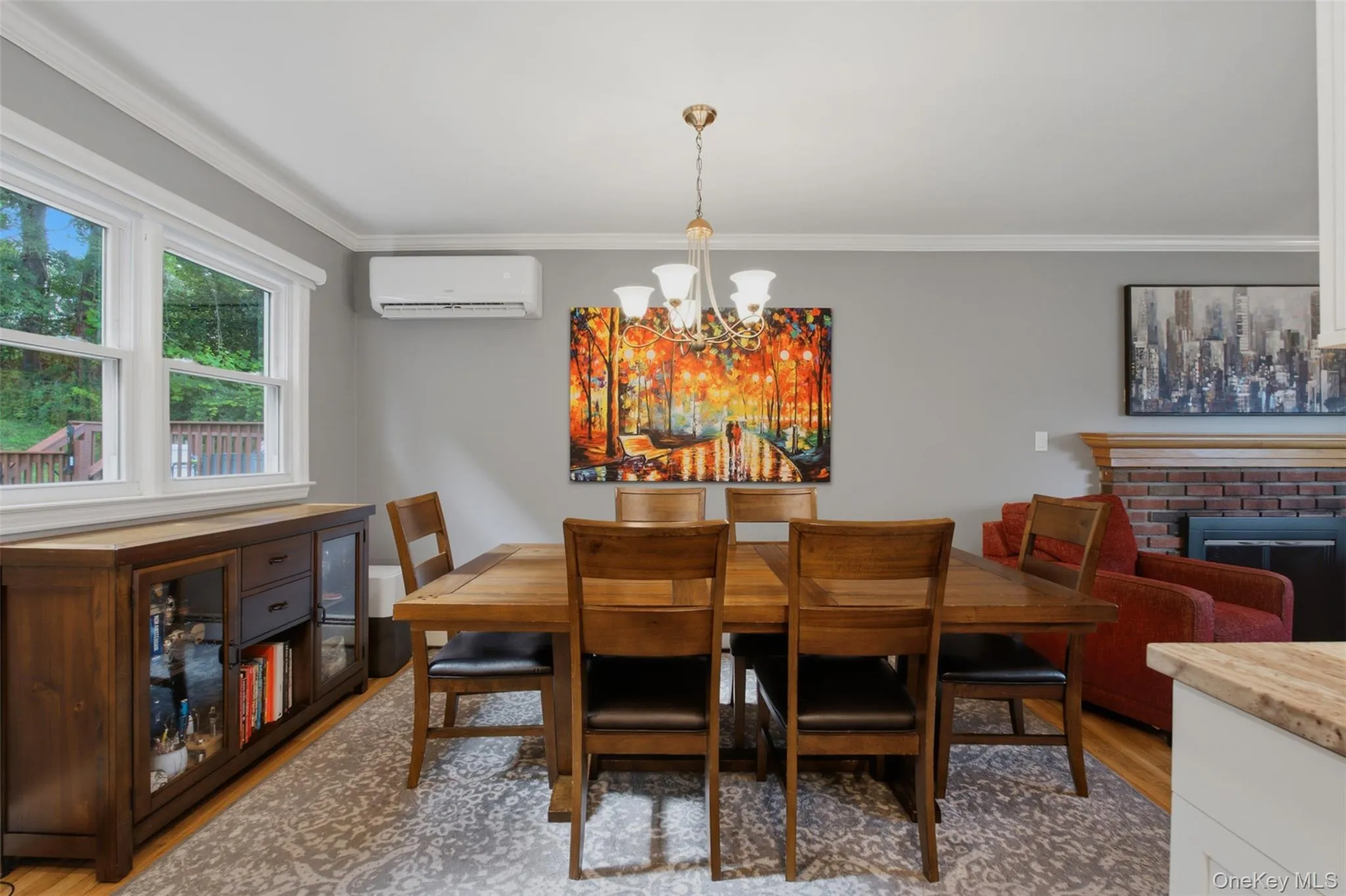 Bright dining area featuring hardwood flooring, crown molding, and a chandelier Bright dining area featuring hardwood flooring, crown molding, and a chandelier