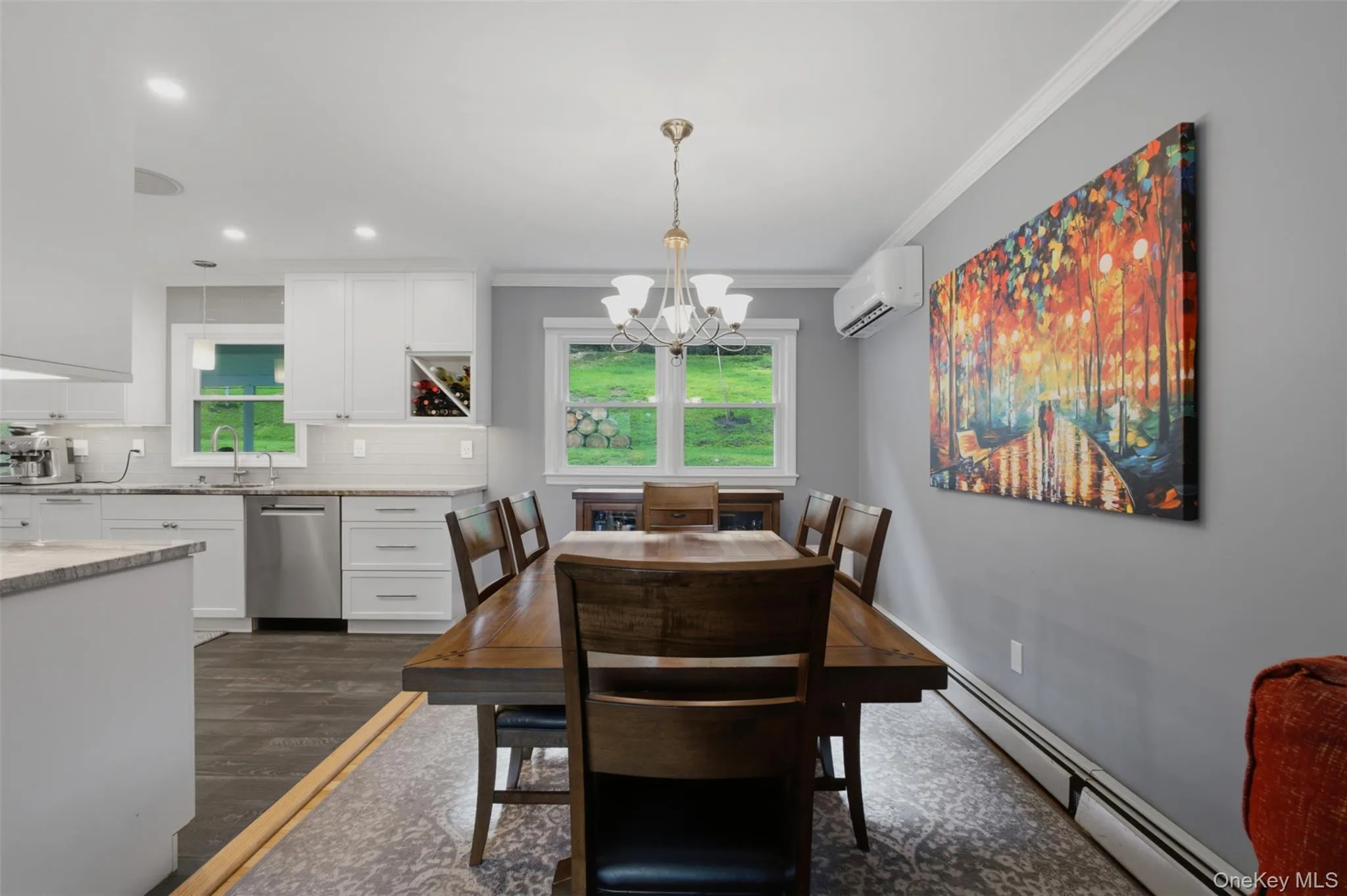 Dining area featuring a wood-finish table with seating for six, illuminated by a central chandelier Dining area featuring a wood-finish table with seating for six, illuminated by a central chandelier