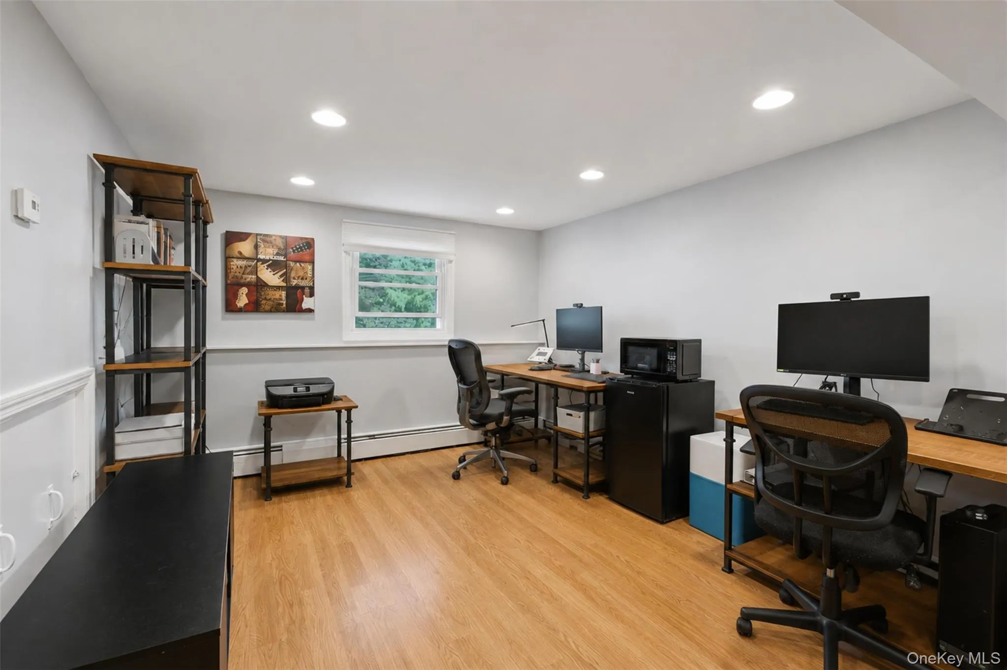 Versatile room featuring wood-finish flooring, recessed lighting, and a window providing natural illumination Versatile room featuring wood-finish flooring, recessed lighting, and a window providing natural illumination