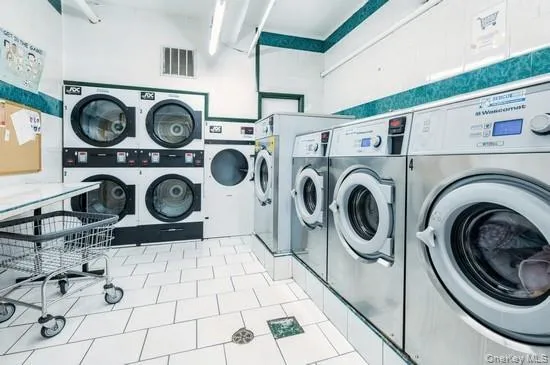 Laundry area with washing machine and dryer and stacked washer and clothes dryer Laundry area with washing machine and dryer and stacked washer and clothes dryer