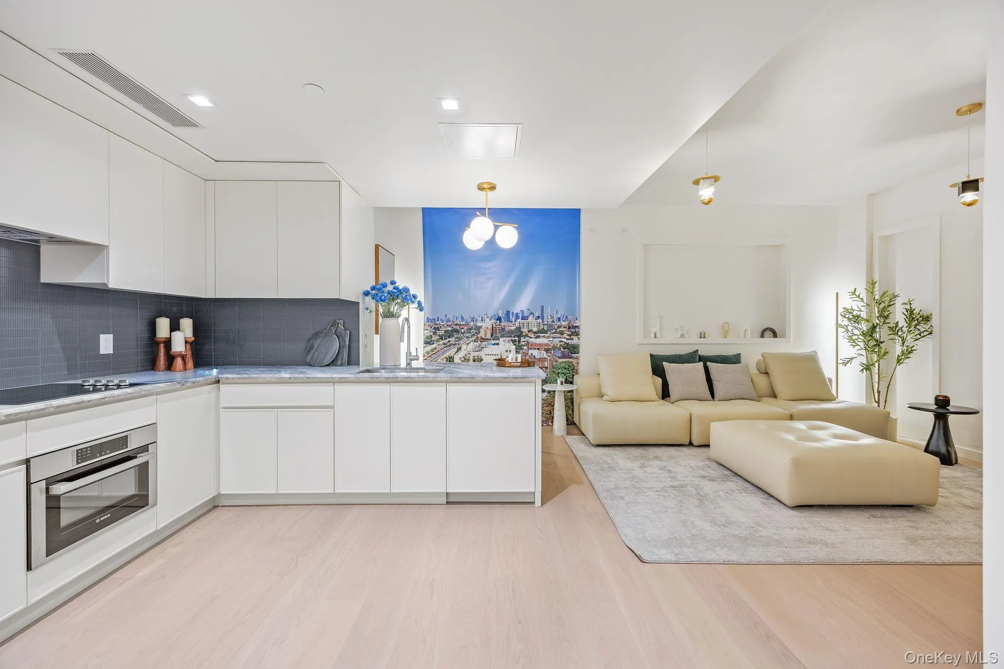 Kitchen with modern cabinets, stainless steel oven, white cabinets, and hanging light fixtures Kitchen with modern cabinets, stainless steel oven, white cabinets, and hanging light fixtures