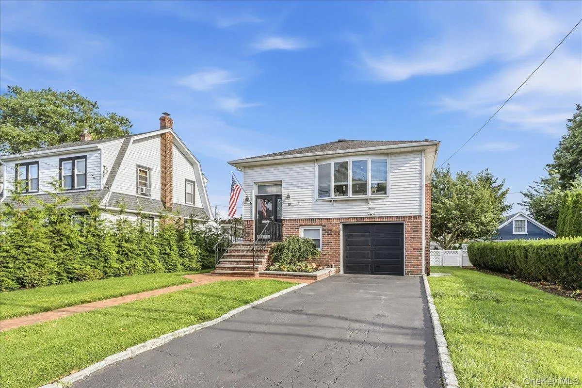 Two-story residence featuring a brick and siding exterior, a prominent bay window, and a single-car garage Two-story residence featuring a brick and siding exterior, a prominent bay window, and a single-car garage